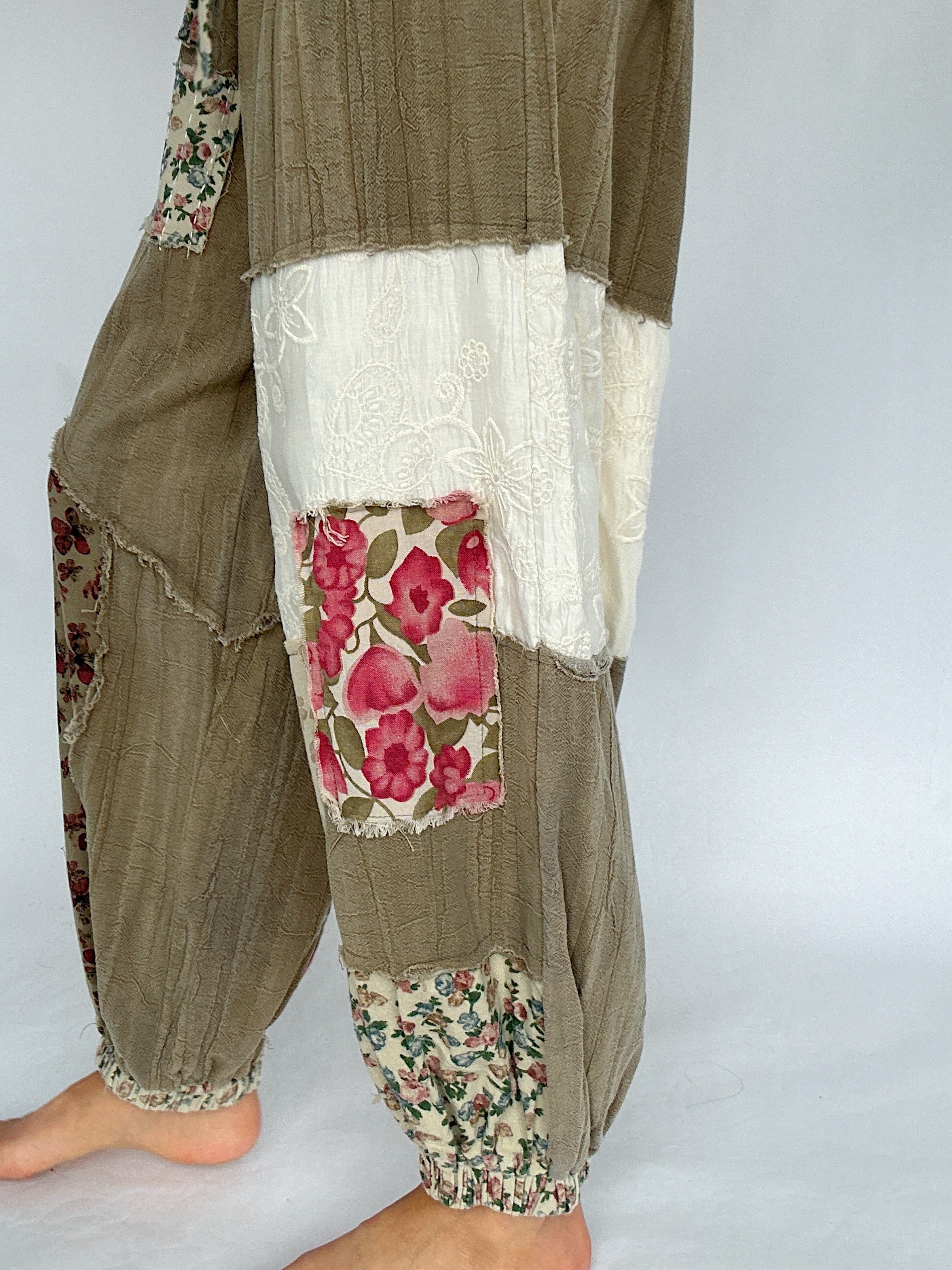 Patchwork pants with floral patterns on a plain background showing up close detail