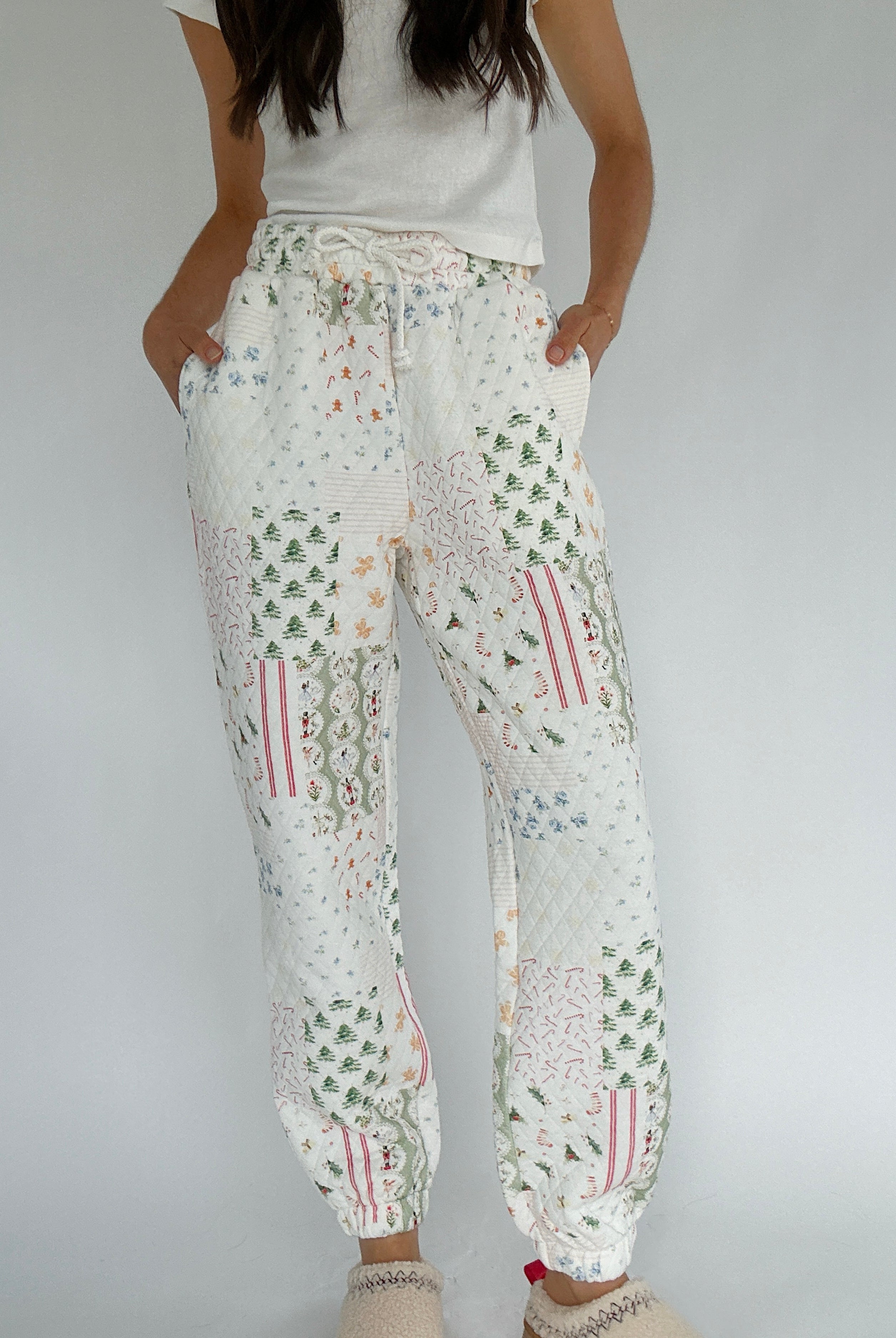 Person wearing holiday-patterned jogger pants on a plain background