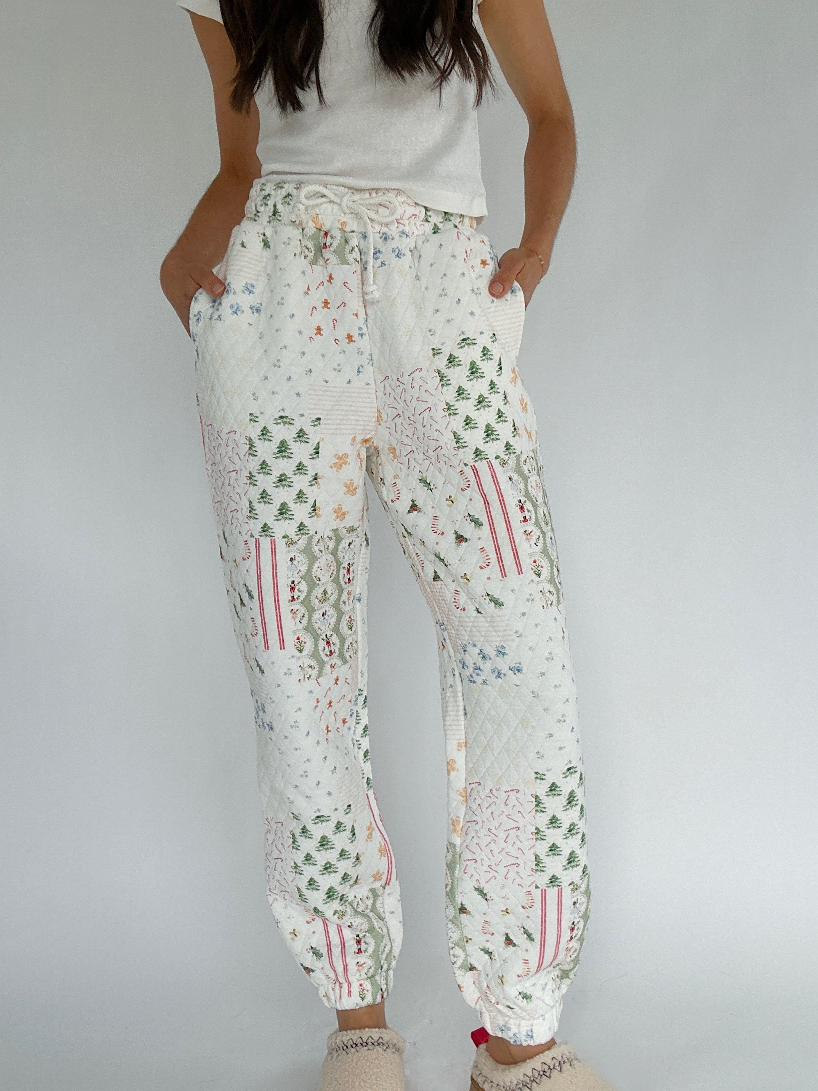 Person wearing holiday-patterned jogger pants on a plain background