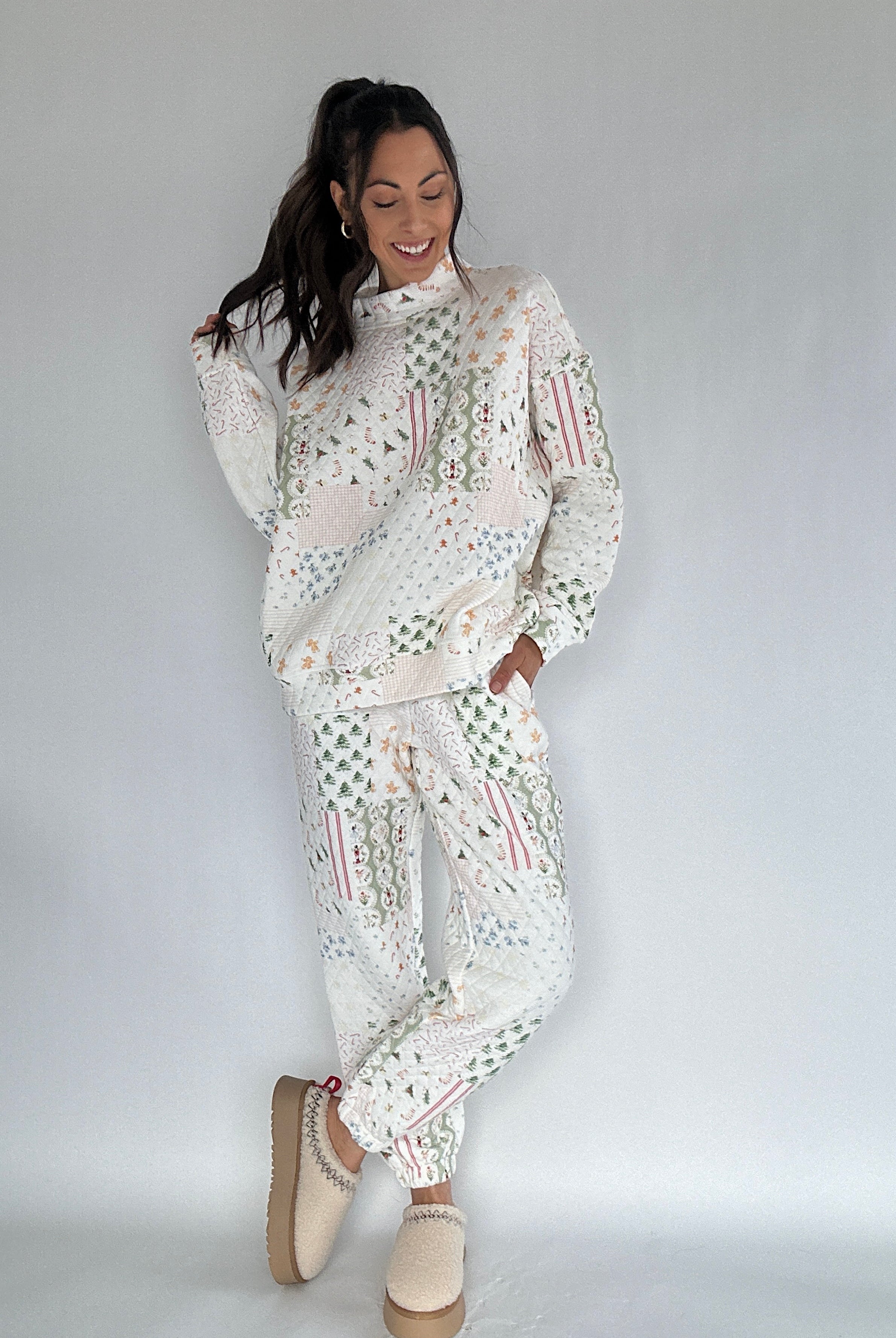 Woman wearing a white quilted holiday patterned matching set on a plain background