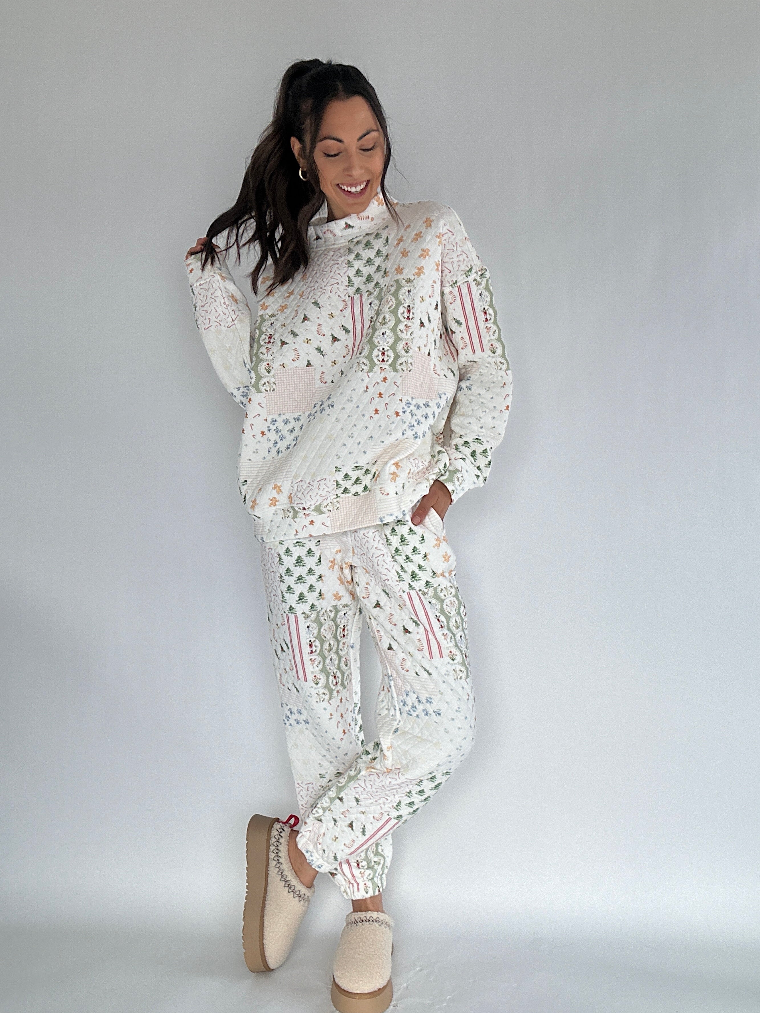 Woman wearing a white quilted holiday patterned matching set on a plain background
