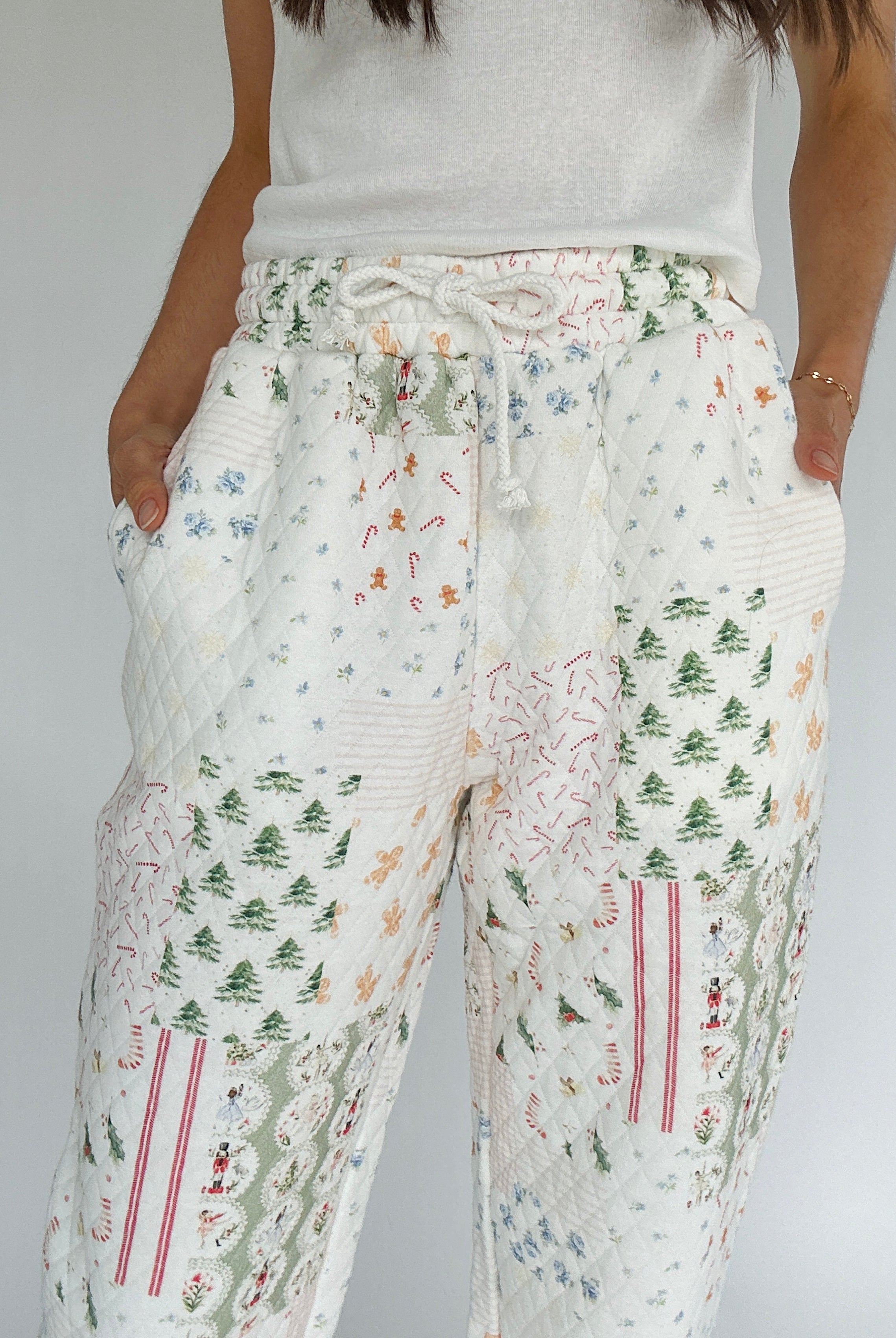 Holiday patterned pants worn by a person on a plain background showing elastic and drawstring waist