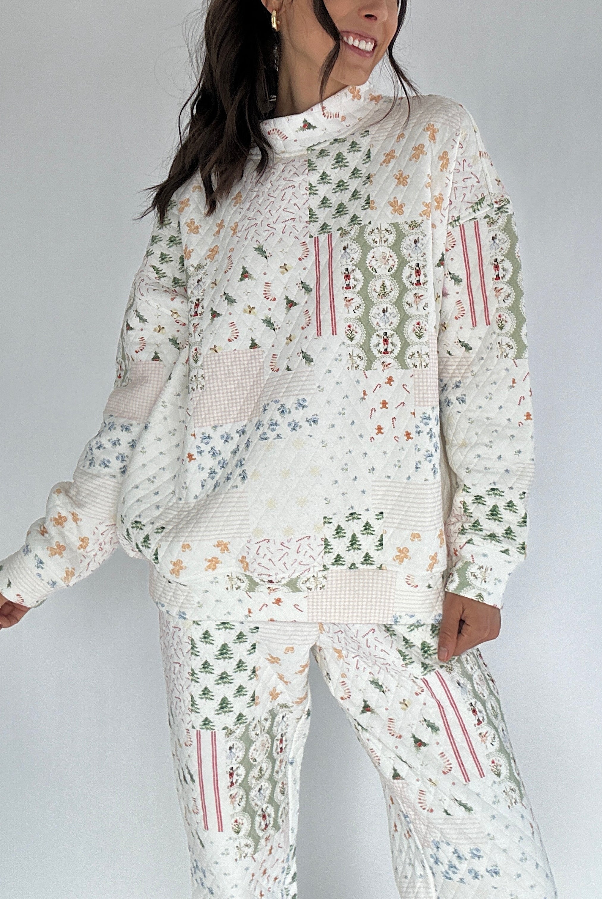 Person wearing a white quilted outfit with holiday patterns on a plain background