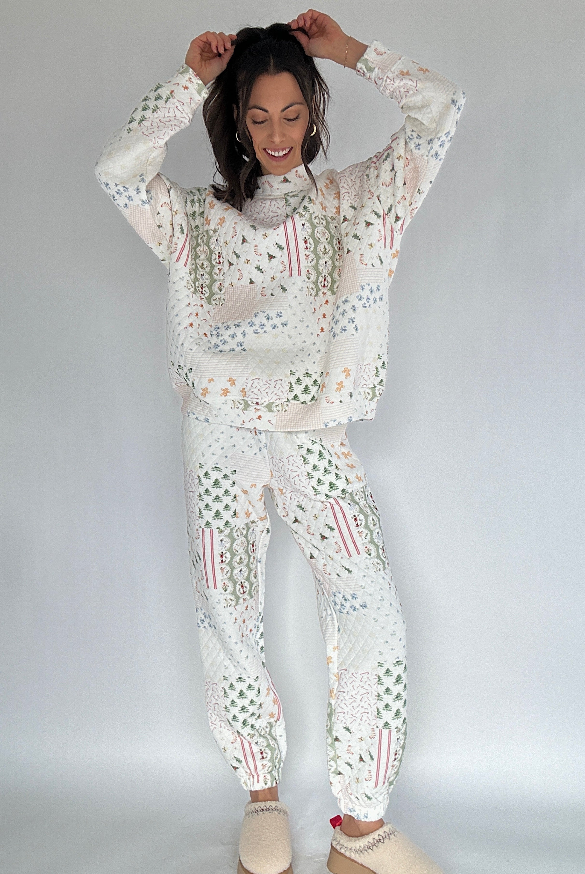 Woman wearing a white quilted holiday patterned outfit against a plain background