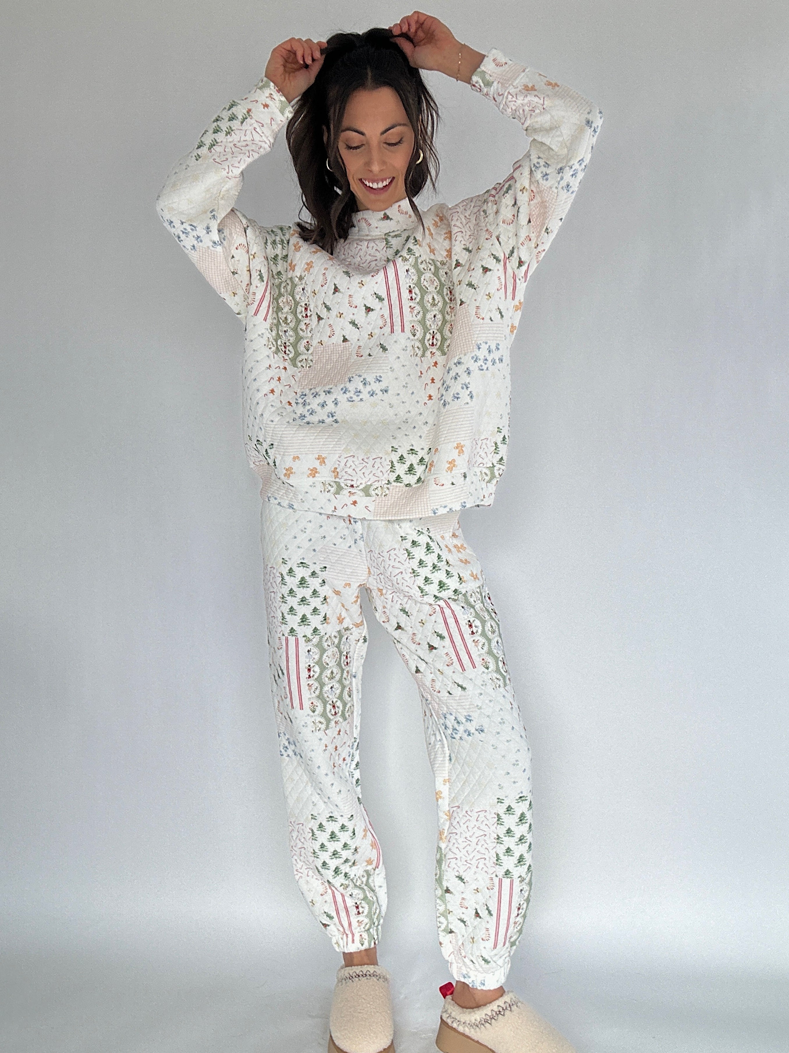 Woman wearing a white quilted holiday patterned outfit against a plain background