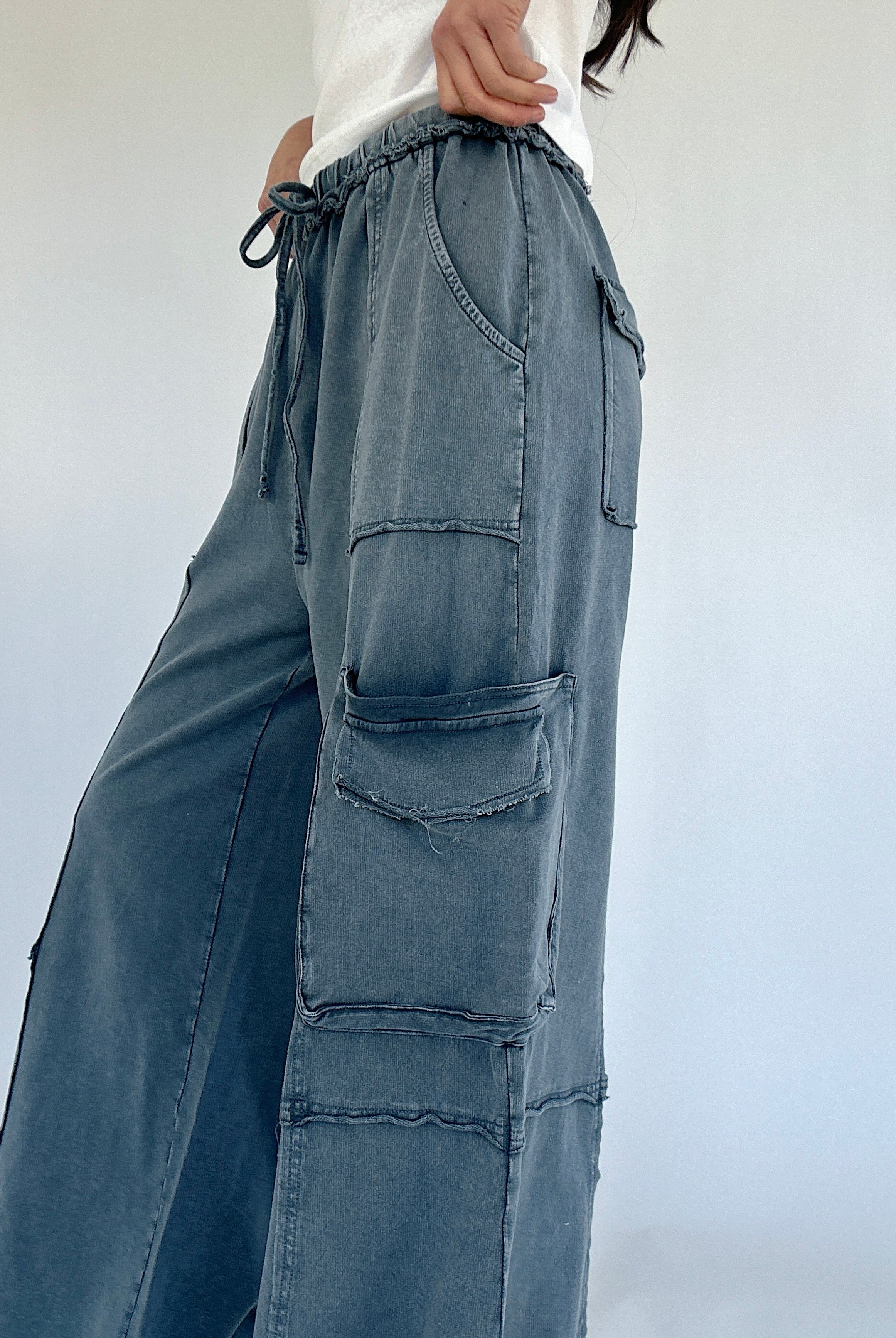 Smoke blue cargo pants with multiple pockets on a plain background