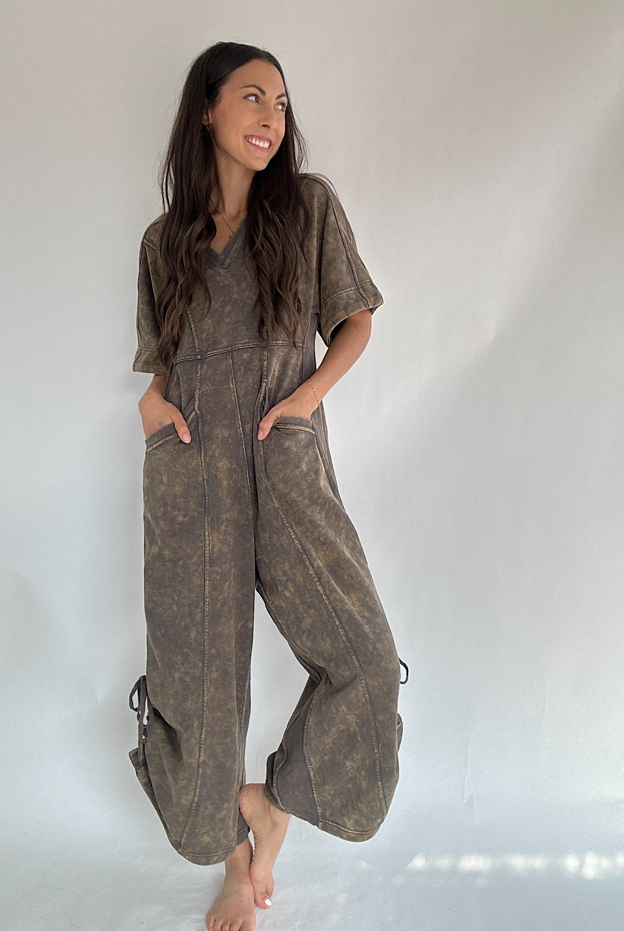 Woman wearing a brown terry knit jumpsuit against a white background