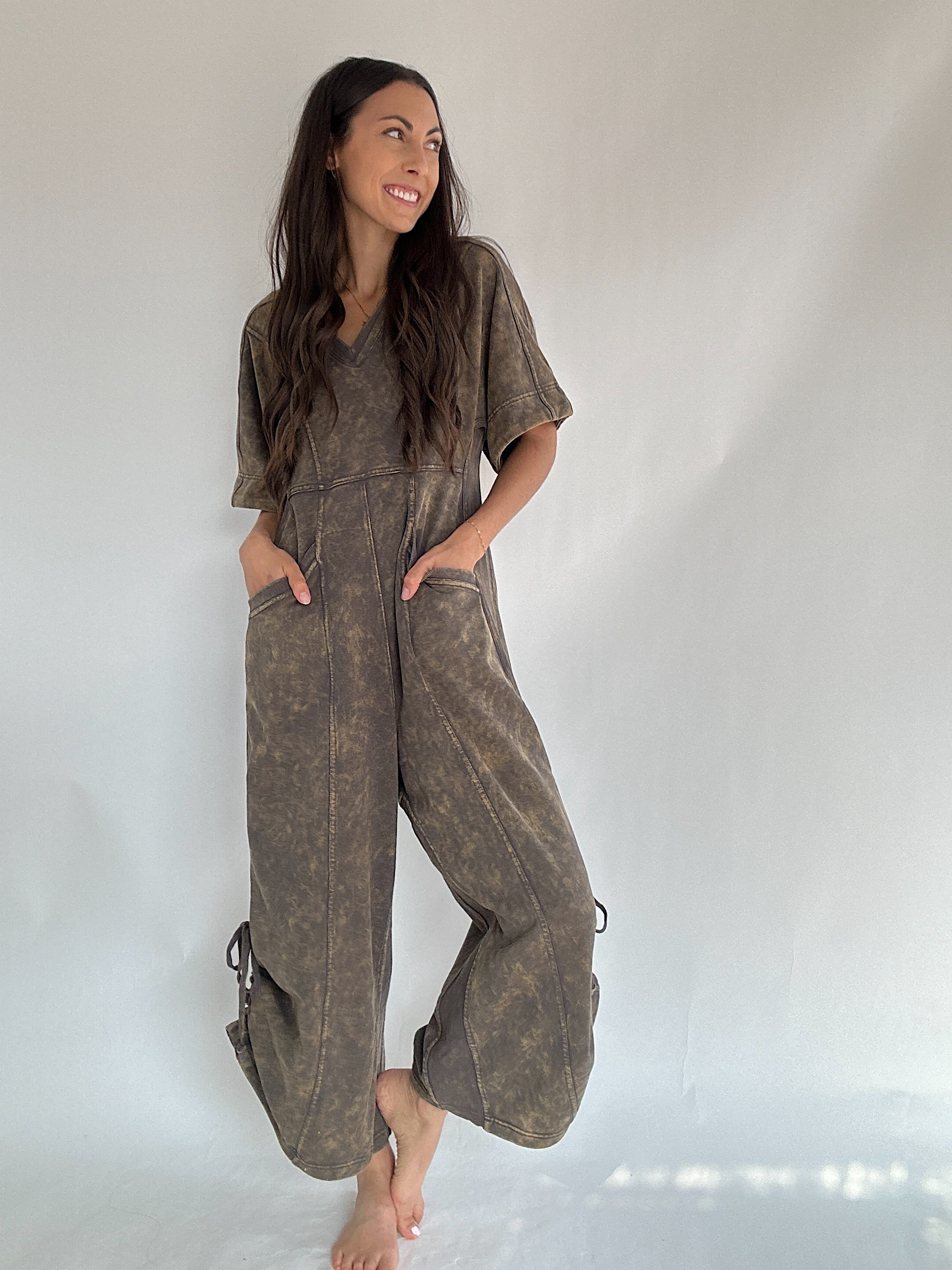 Woman wearing a brown terry knit jumpsuit against a white background