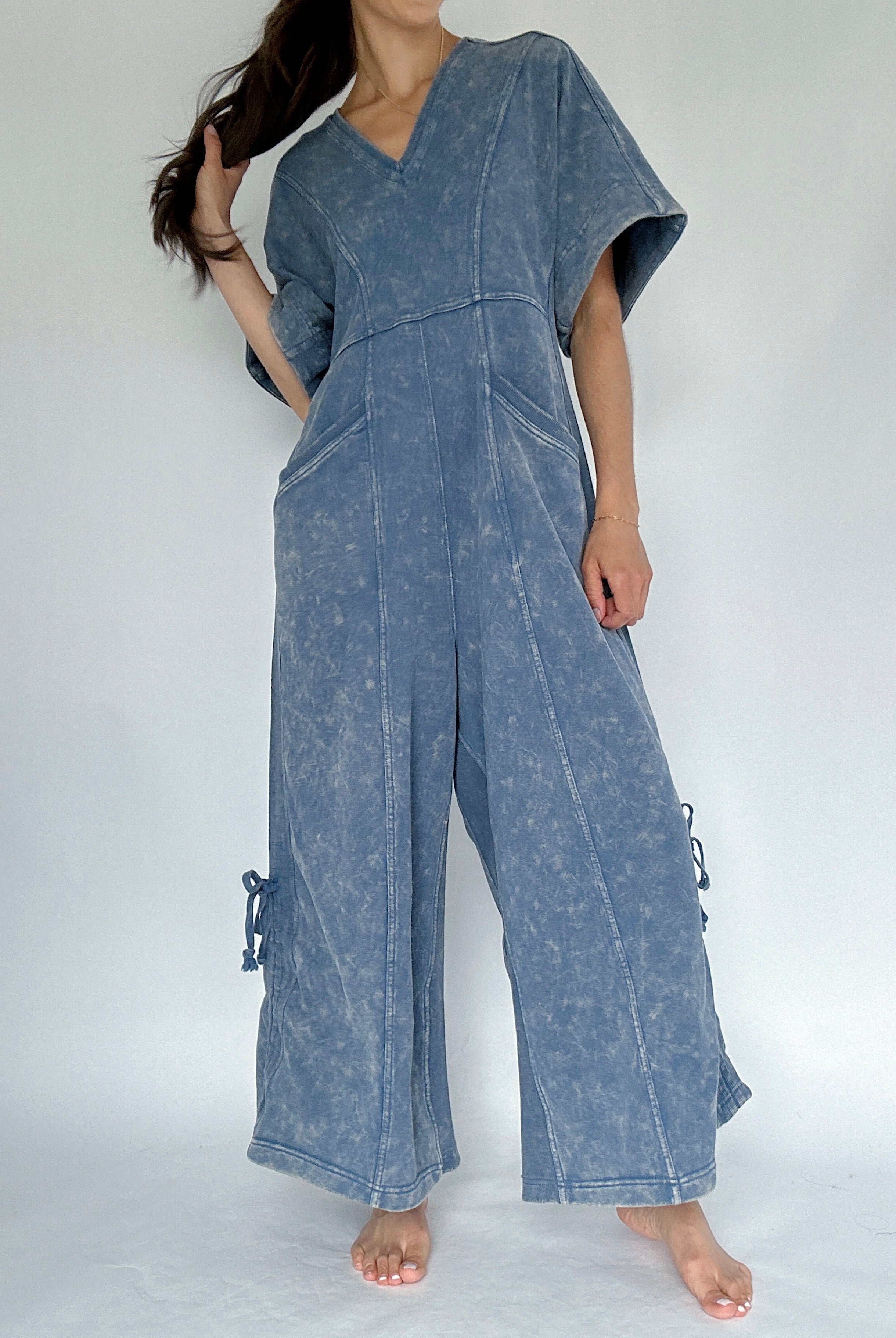 Person wearing a blue denim jumpsuit on a white background