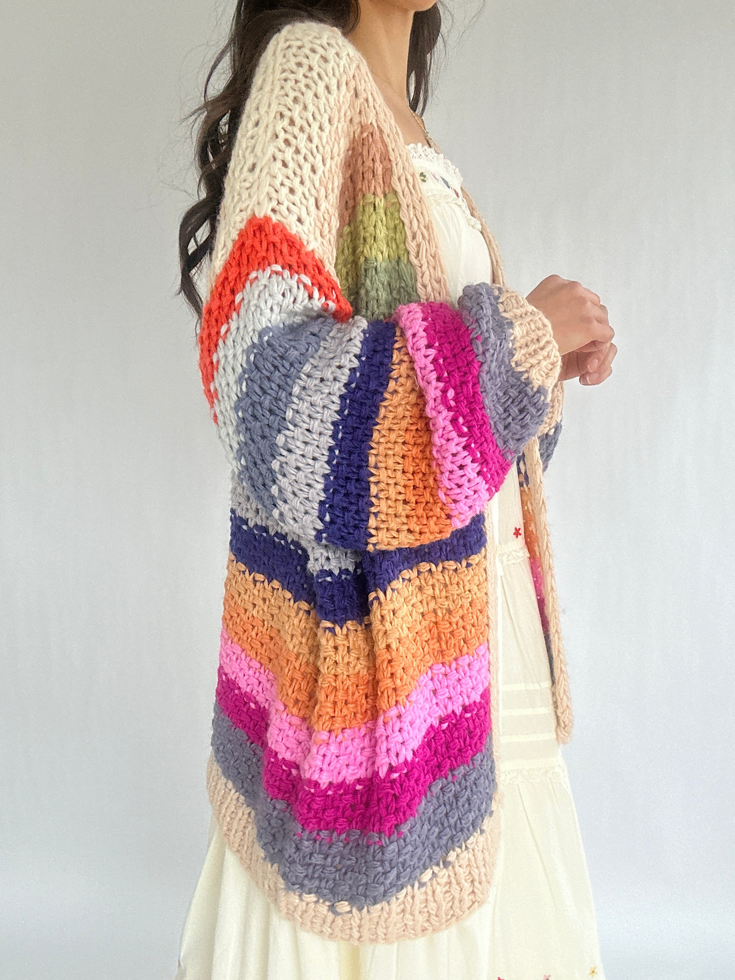 Colorful striped sweater worn by a person on a plain background showing side