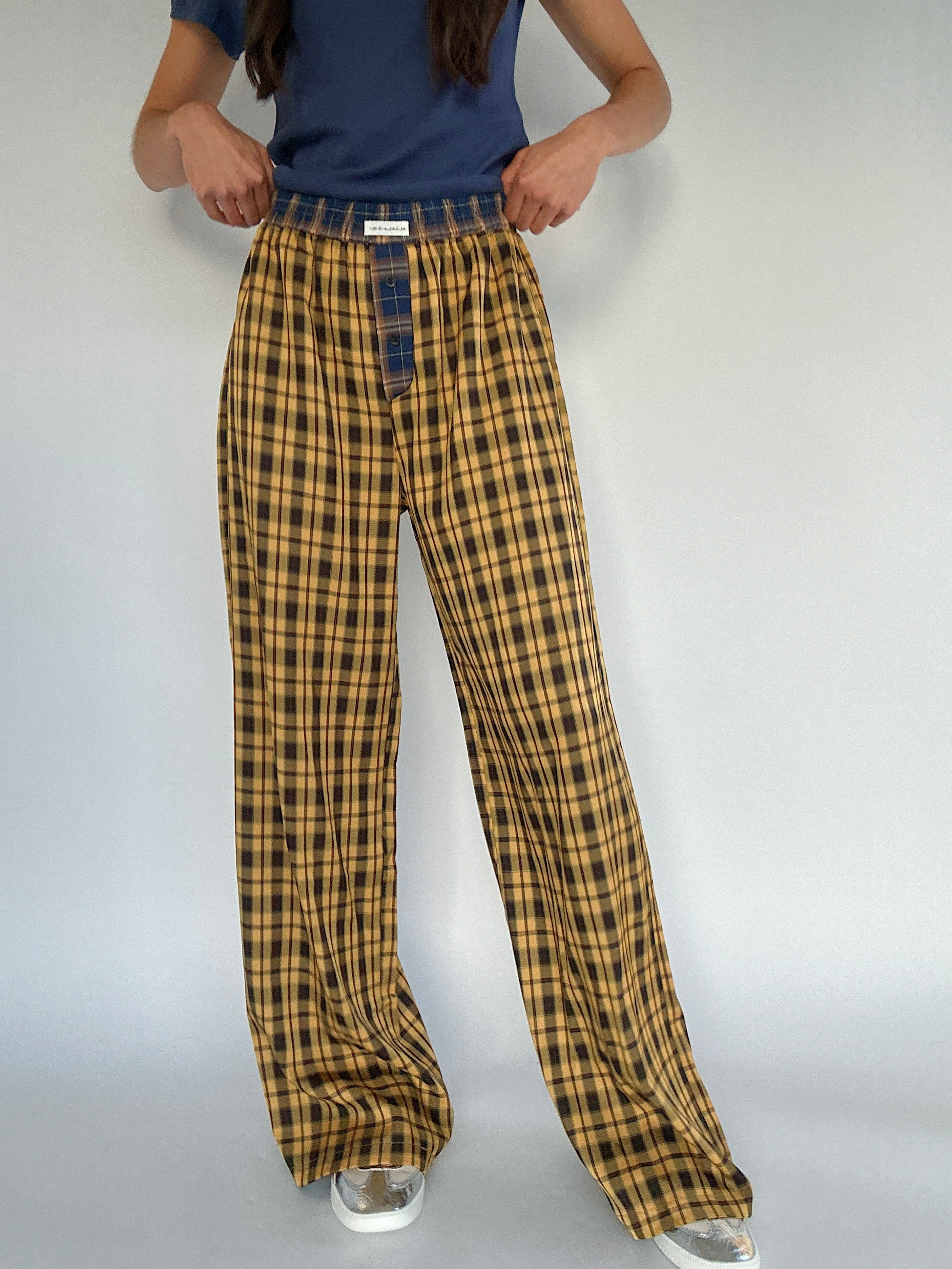 Mustard yellow plaid pants worn by a person on a plain background