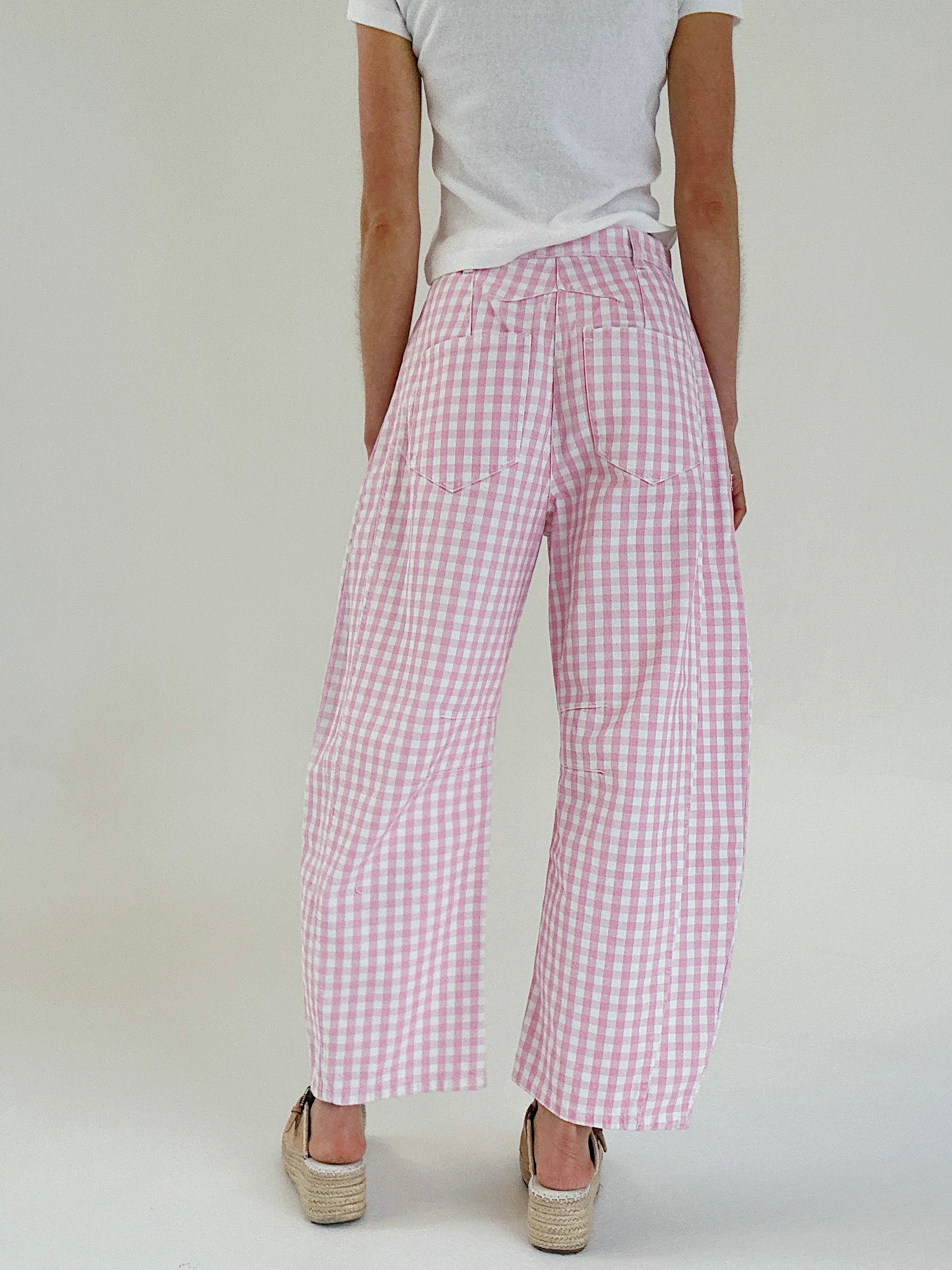 Person wearing pink checkered barrel pants on a plain background from back