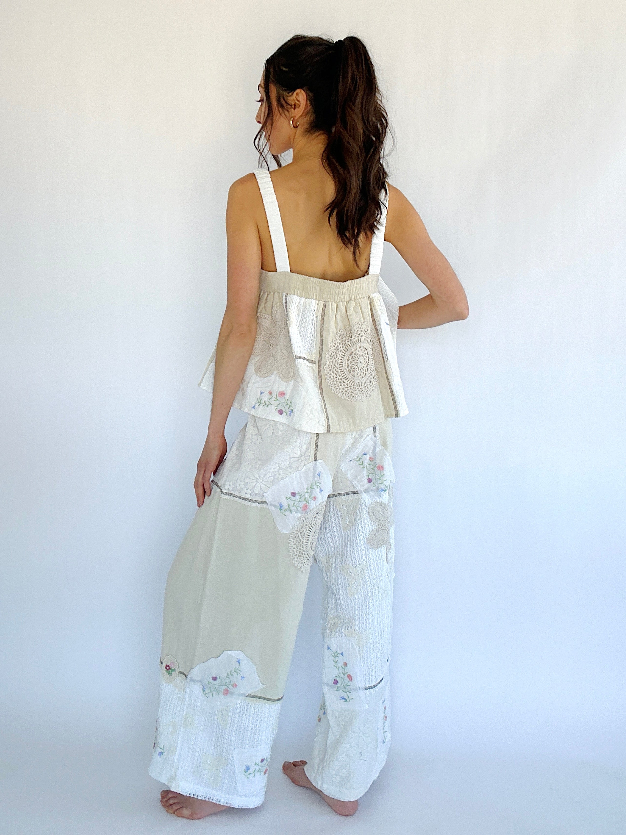 Woman wearing a beige floral top with matching wide-leg pants against a white background from back