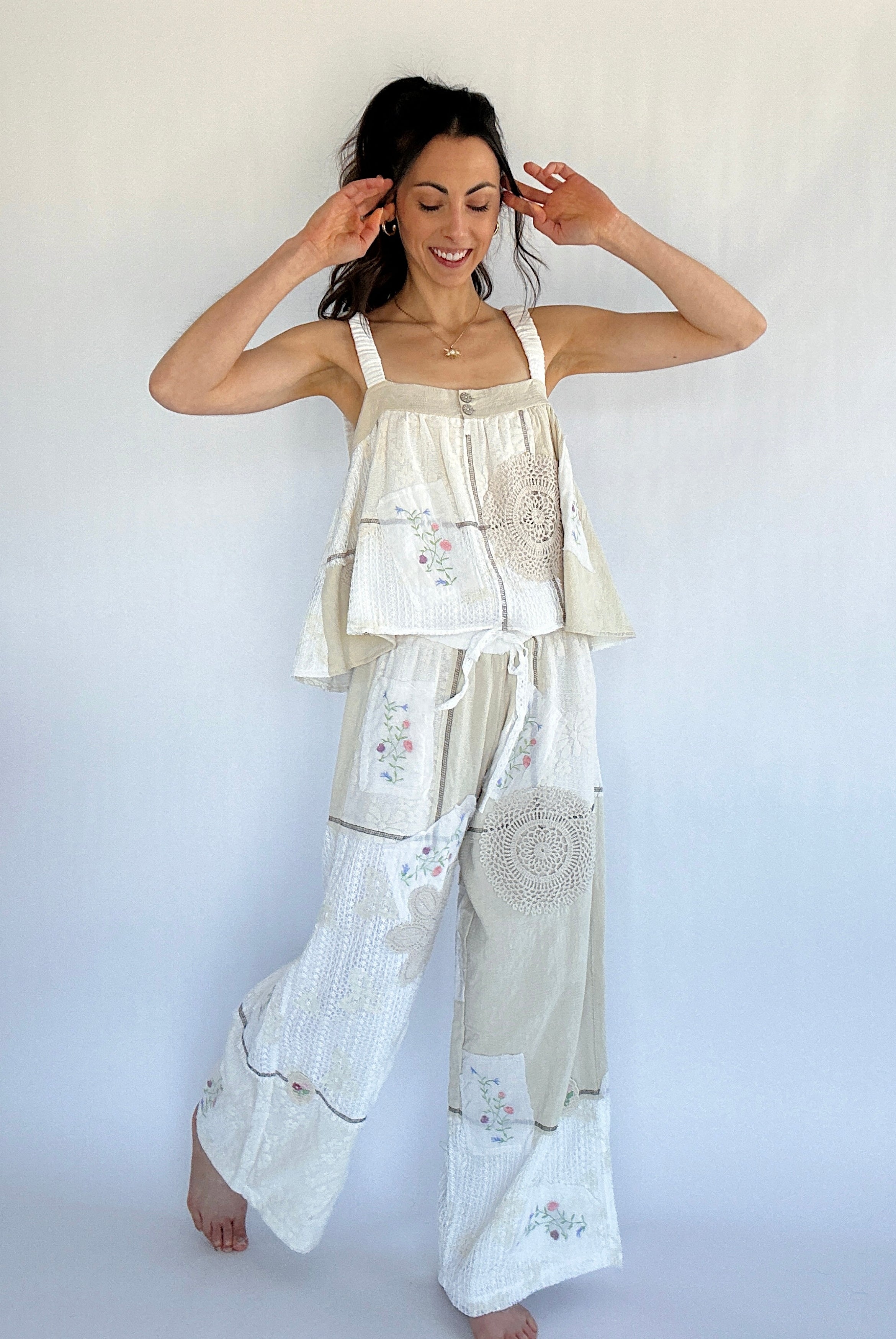 Woman wearing a matching top and pants set with floral patterns against a white background