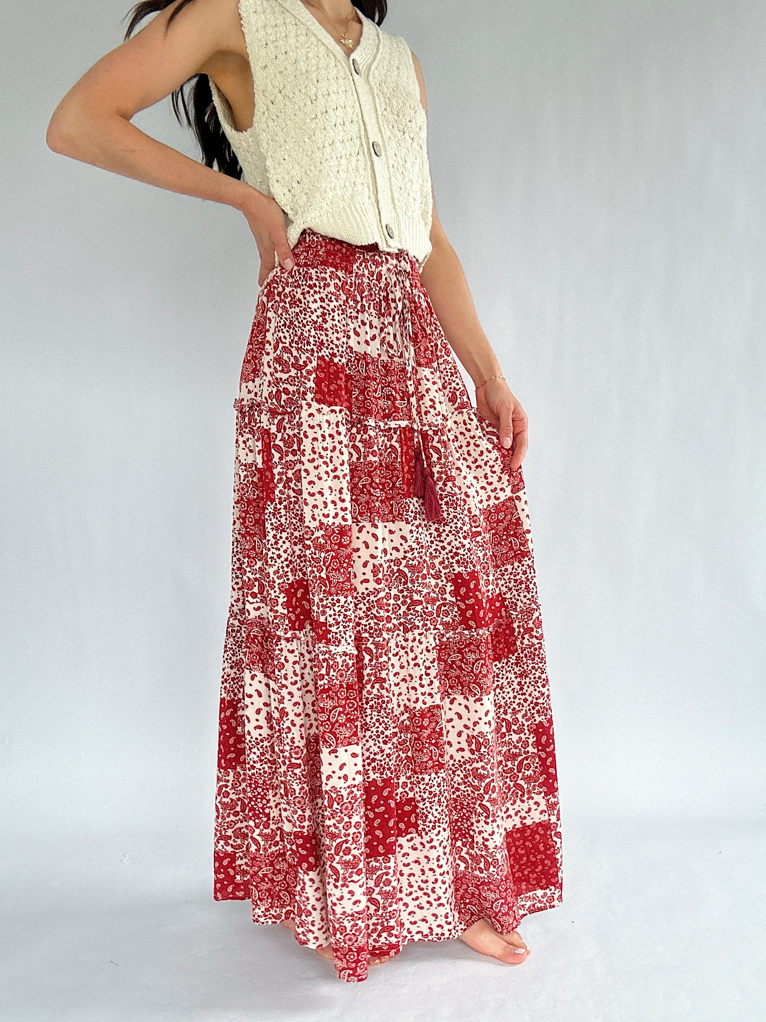 Person wearing a red and white patterned skirt on a plain background