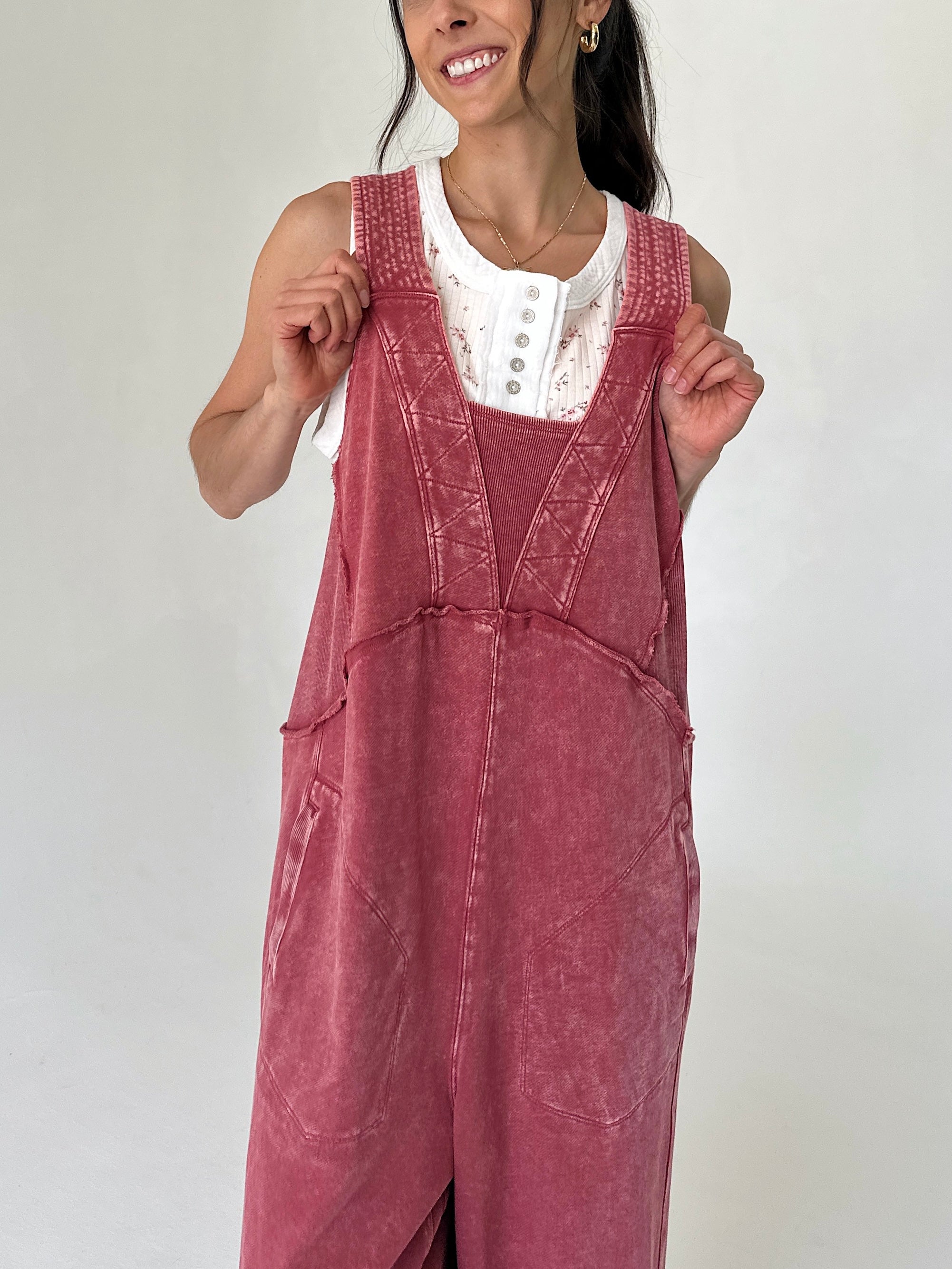 Woman wearing a red terry jumper dress against a plain background