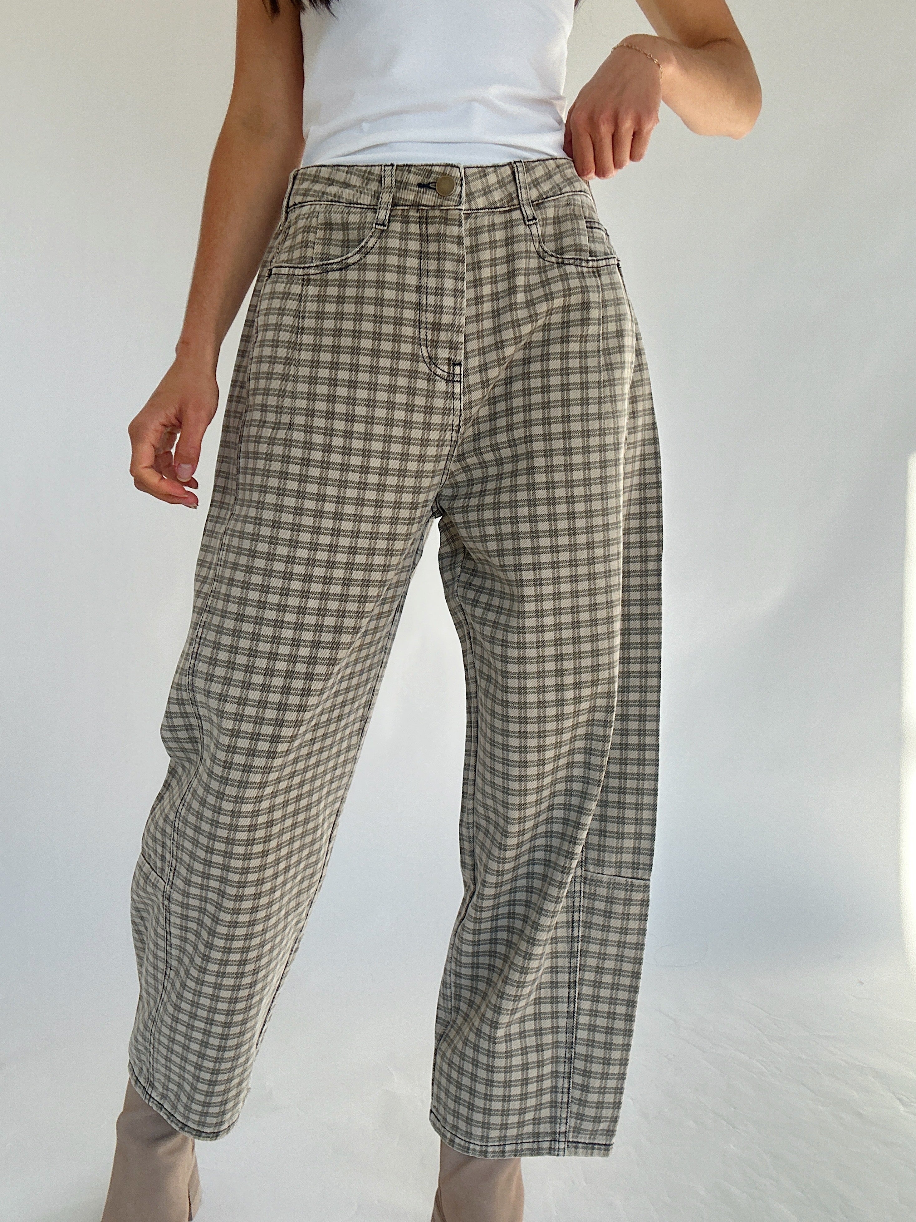 Person wearing plaid pants against a plain background