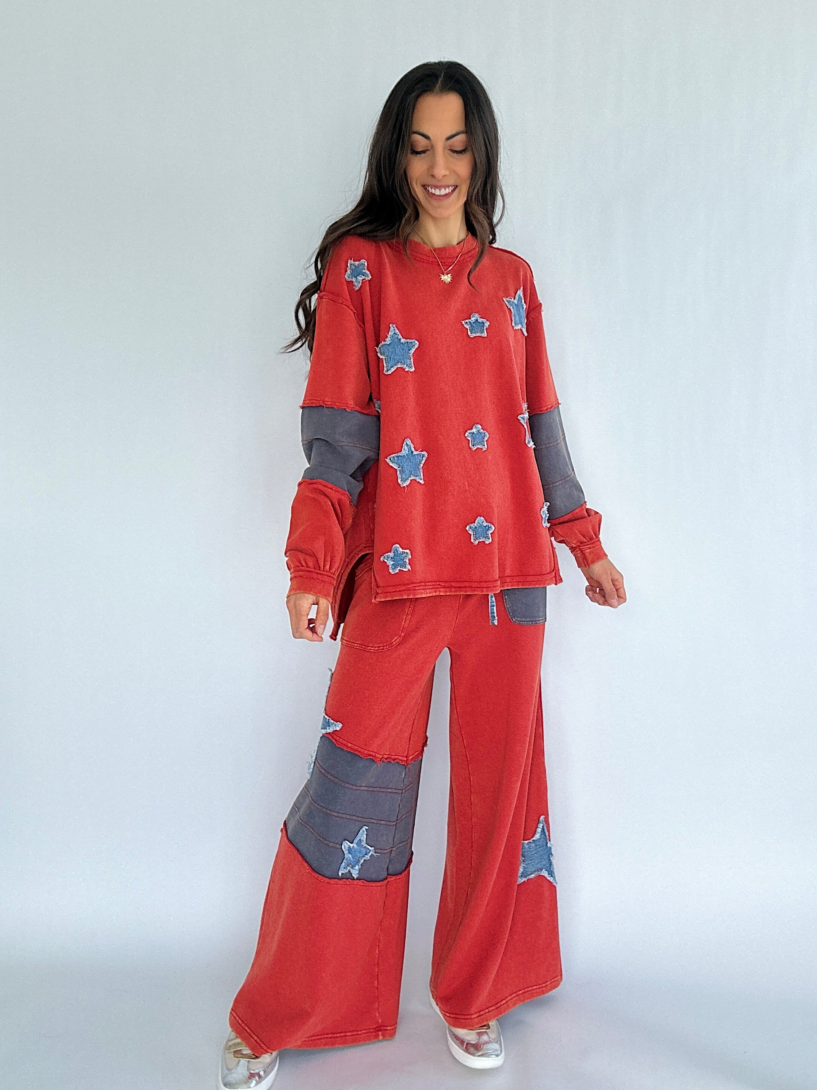 Woman wearing a red outfit with star patches on a white background