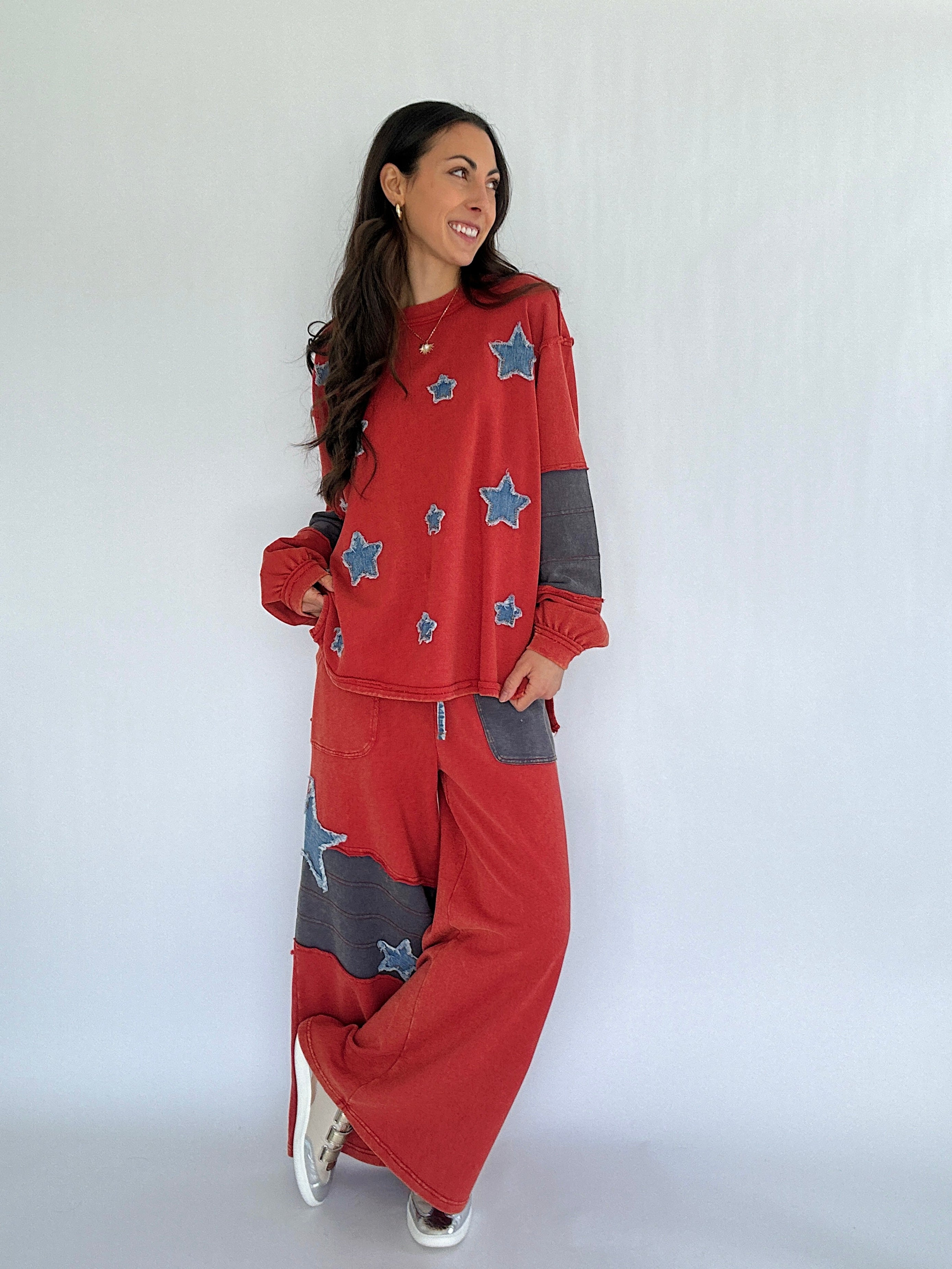 Woman wearing a red outfit with star patterns on a plain background