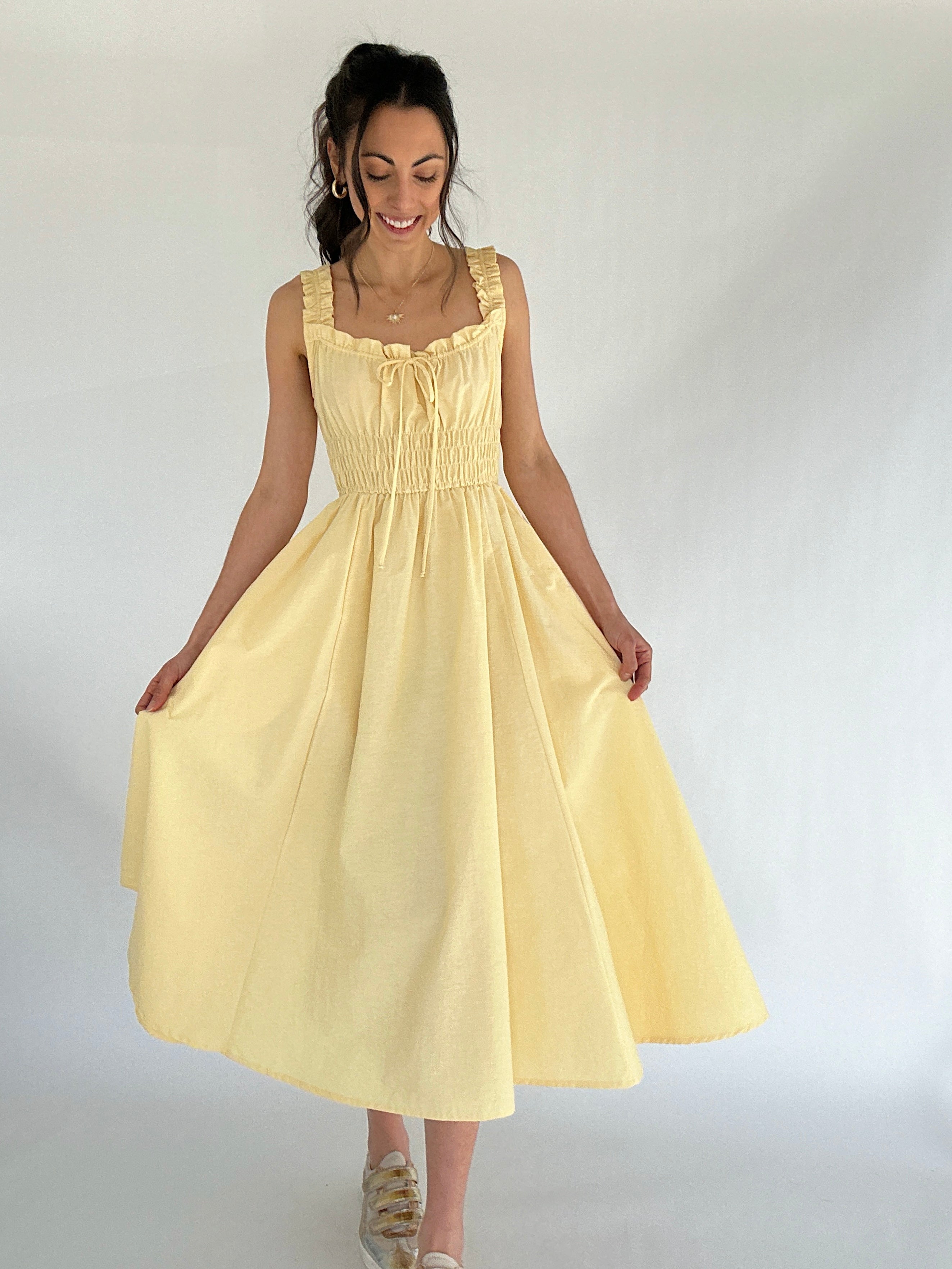 Woman wearing a yellow dress against a white background