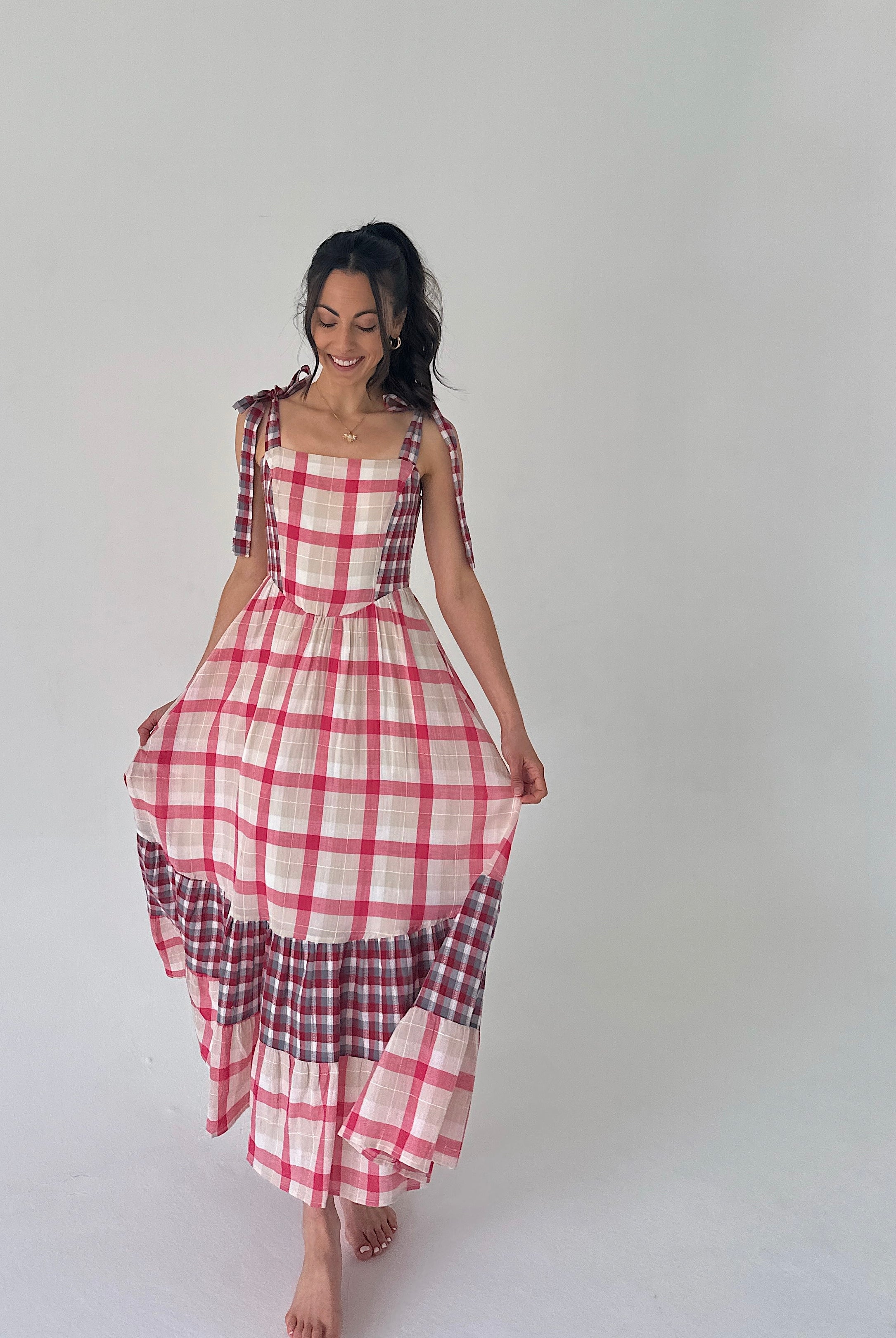 Woman wearing a red and white checkered dress on a plain background
