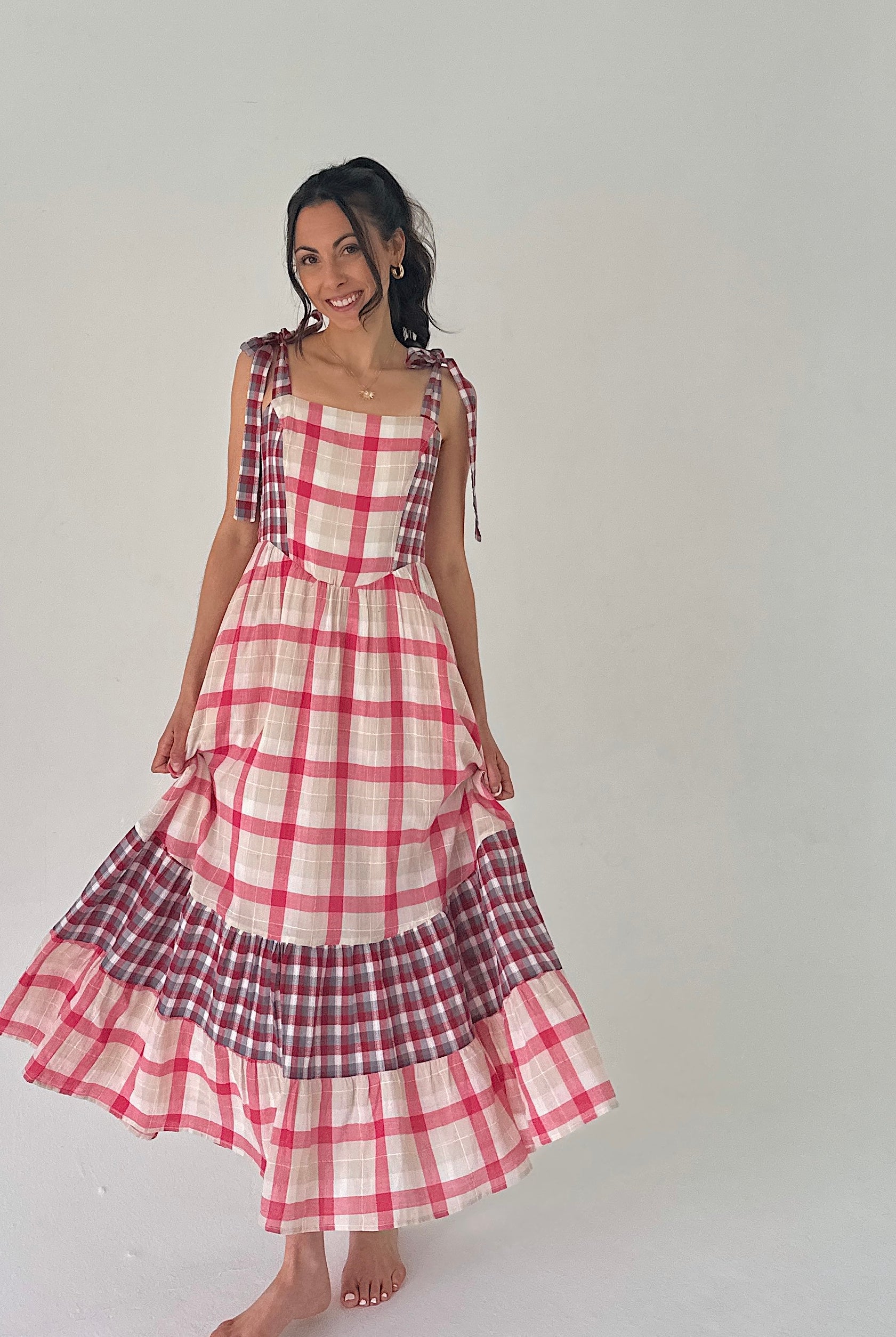 Woman wearing a red and white checkered dress on a plain background