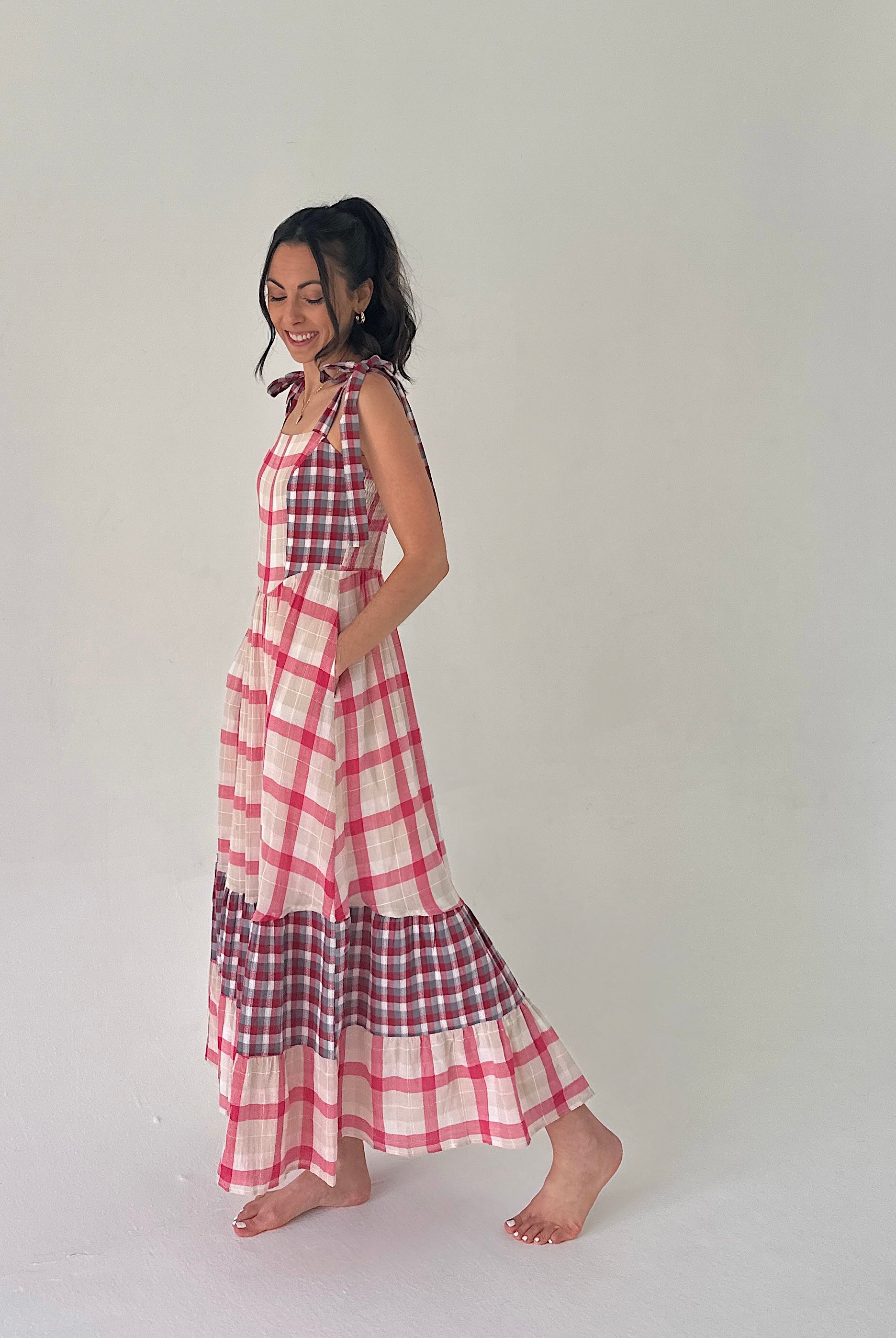 Woman wearing a red and white checkered dress on a plain background