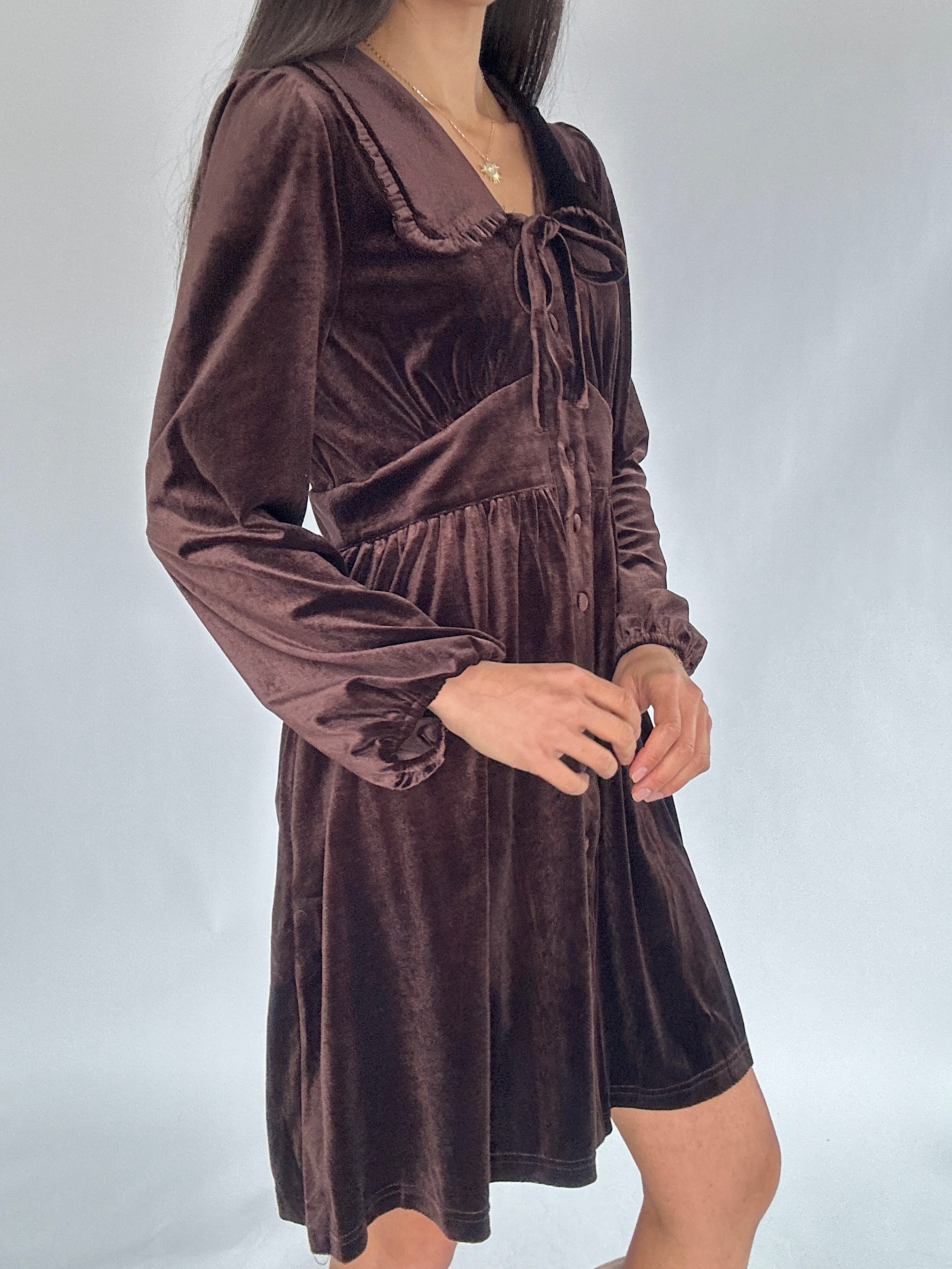 Brown velvet mini dress worn by a person on a white background