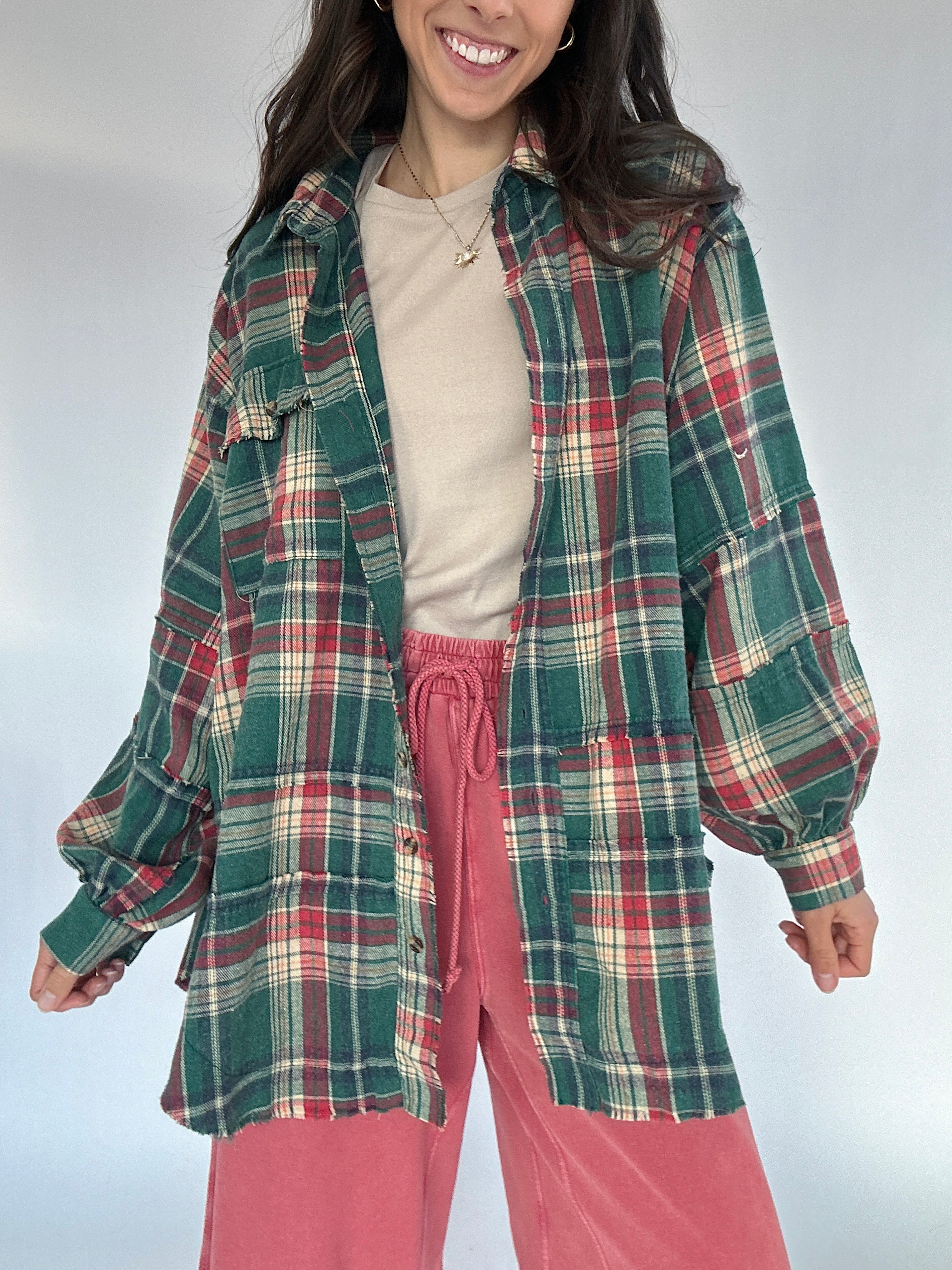Person wearing a green plaid shirt and red sweatpants against a white background