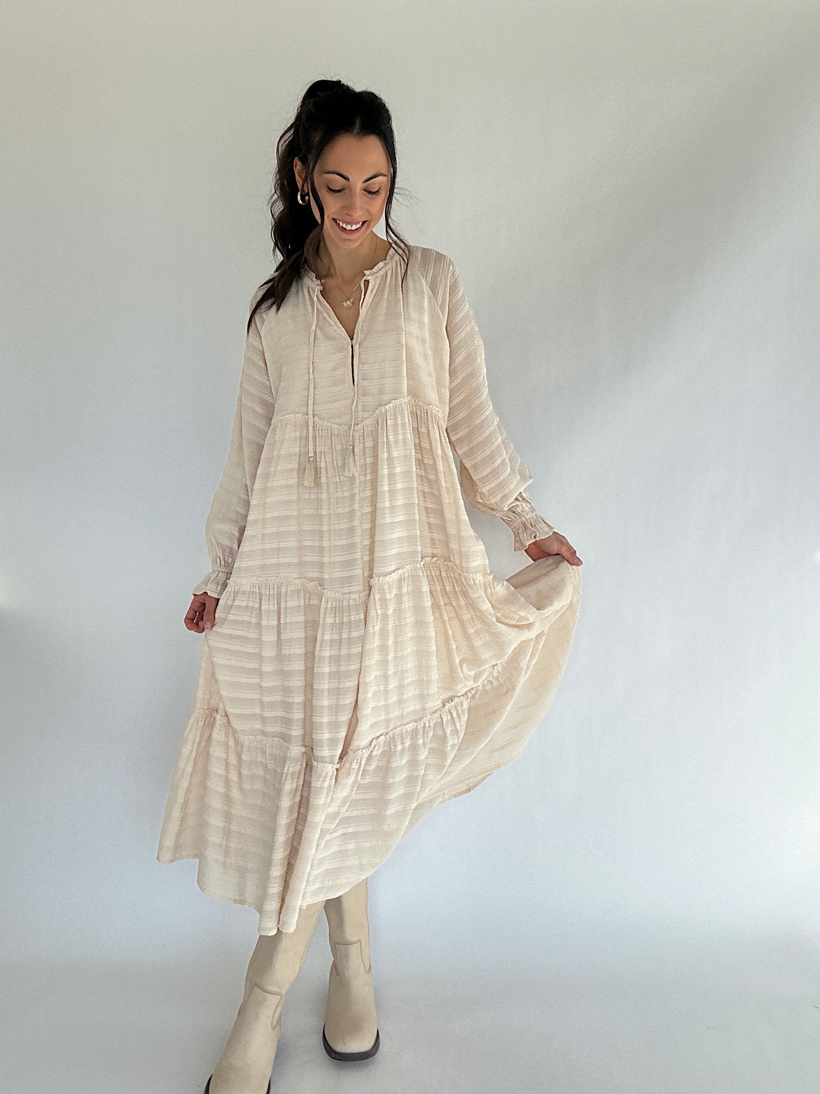 Woman wearing a beige dress against a white background