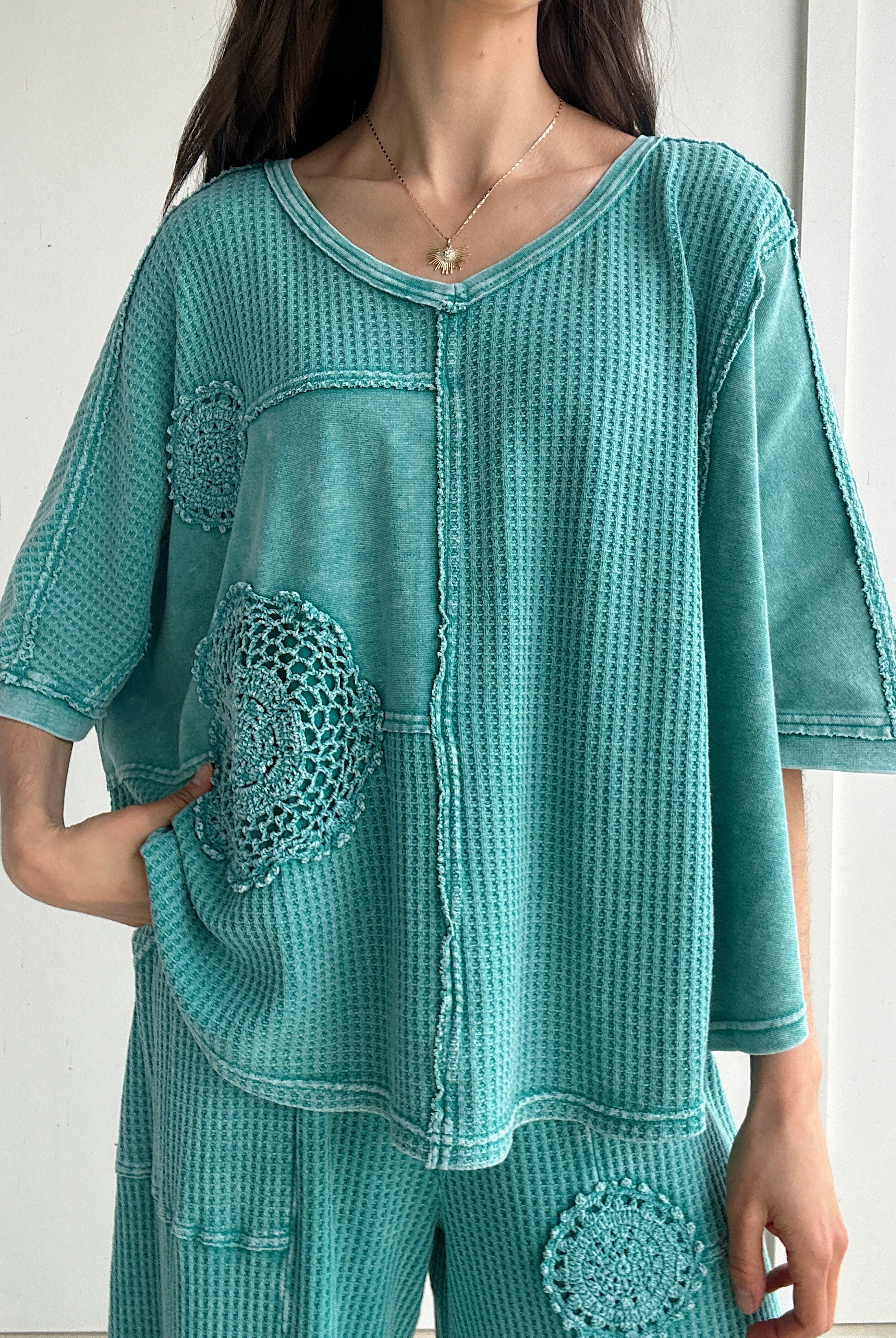 Teal textured outfit with crochet mandala patterns on a white background