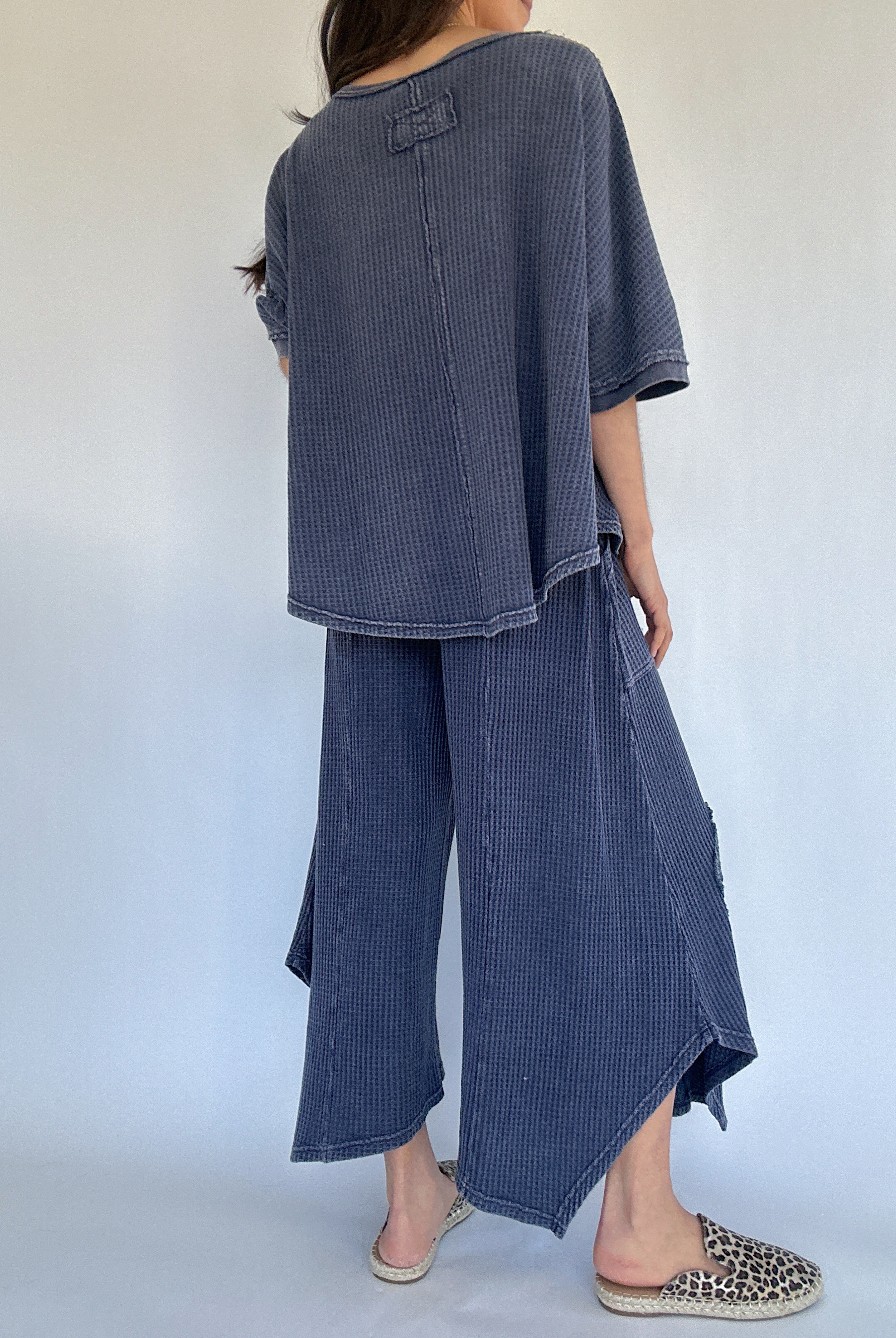 Person wearing a blue waffle knit outfit with wide-leg pants against a white background