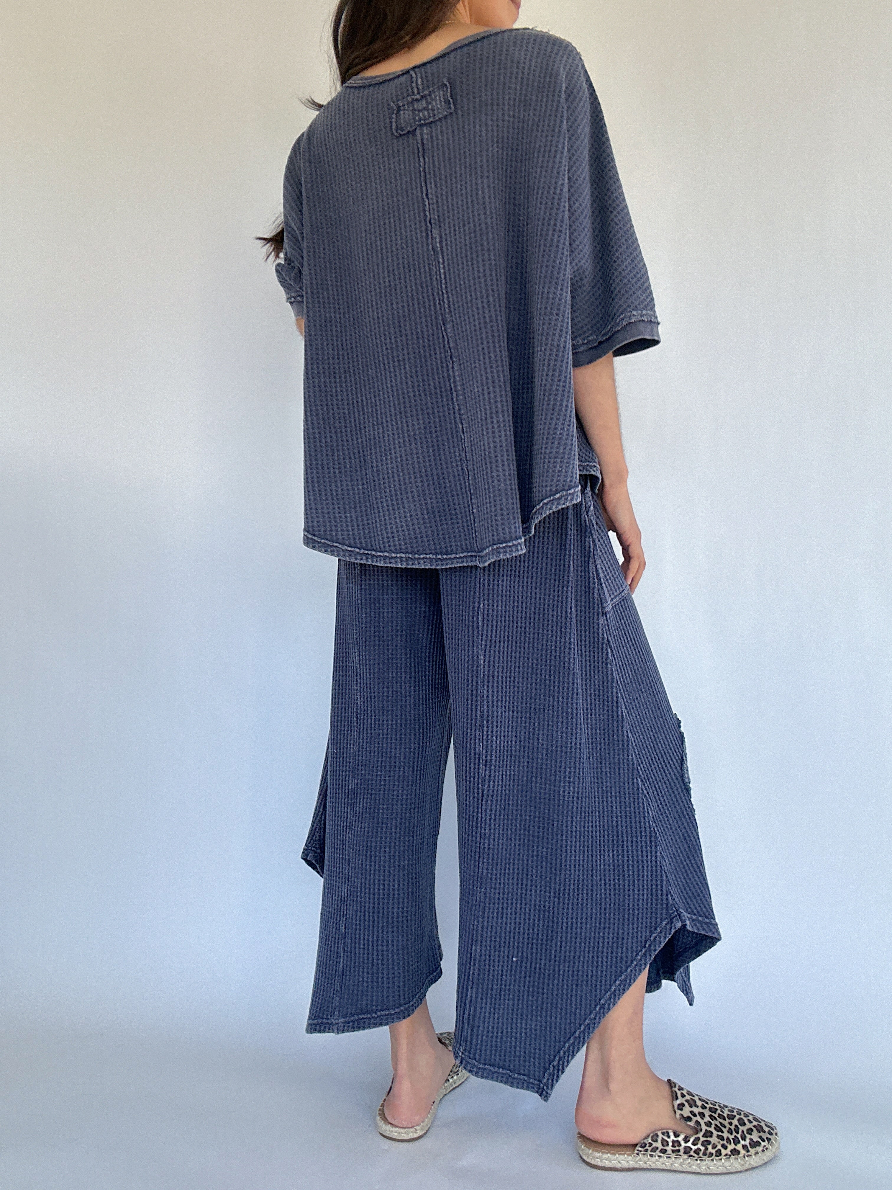 Person wearing a blue waffle knit outfit with wide-leg pants against a white background