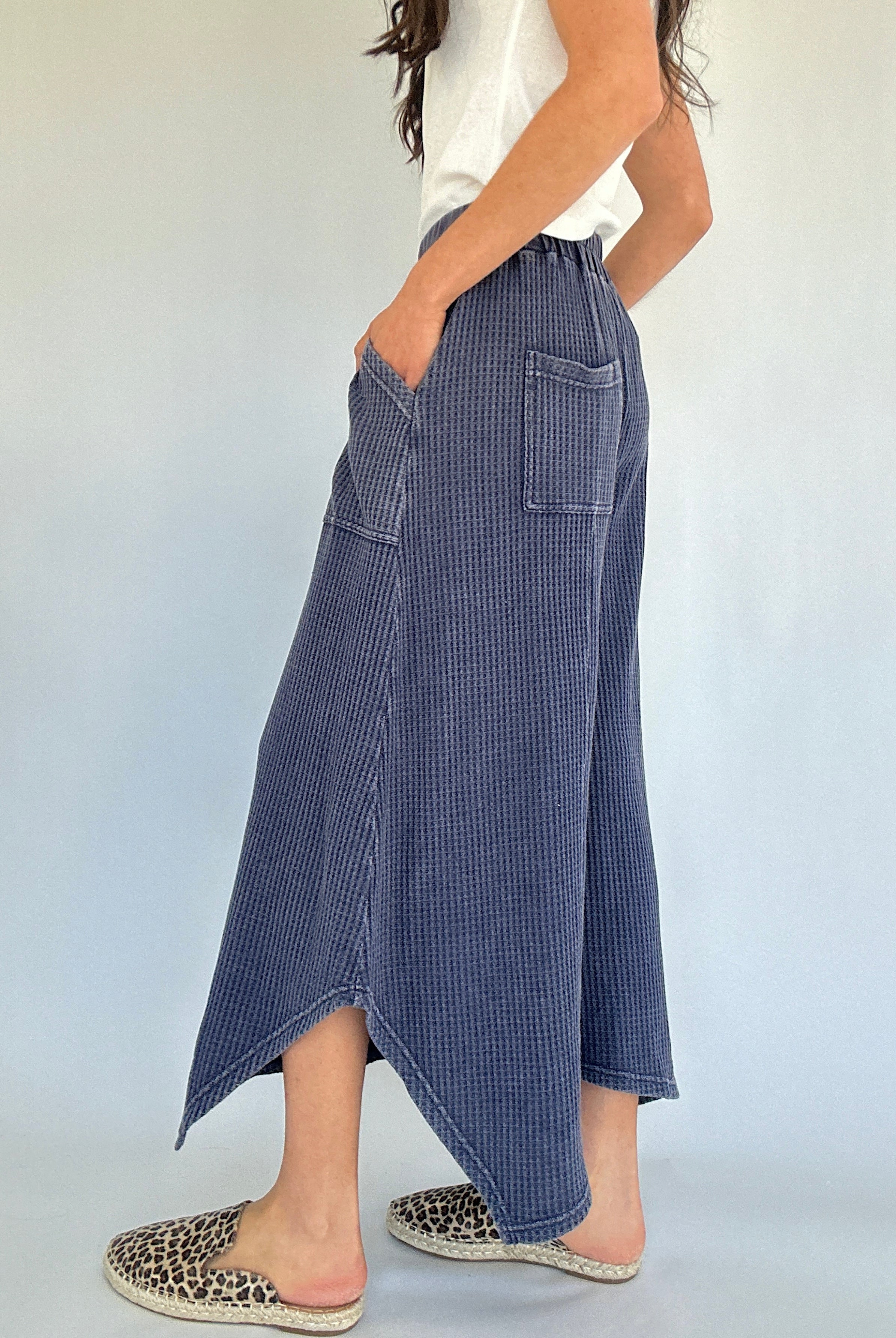 Person wearing blue waffle knit wide leg pants with a white background