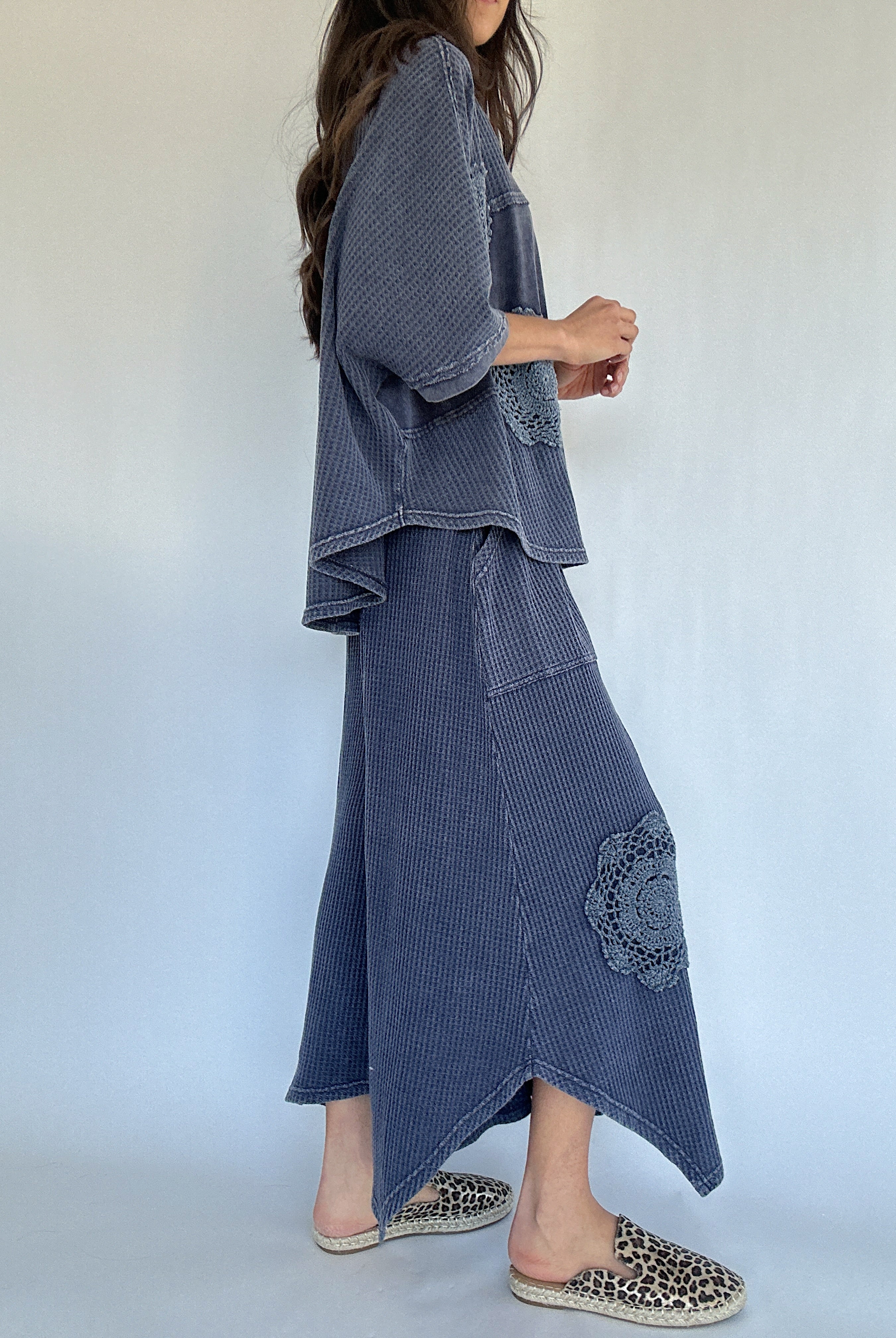 Woman wearing a blue textured outfit with a white background