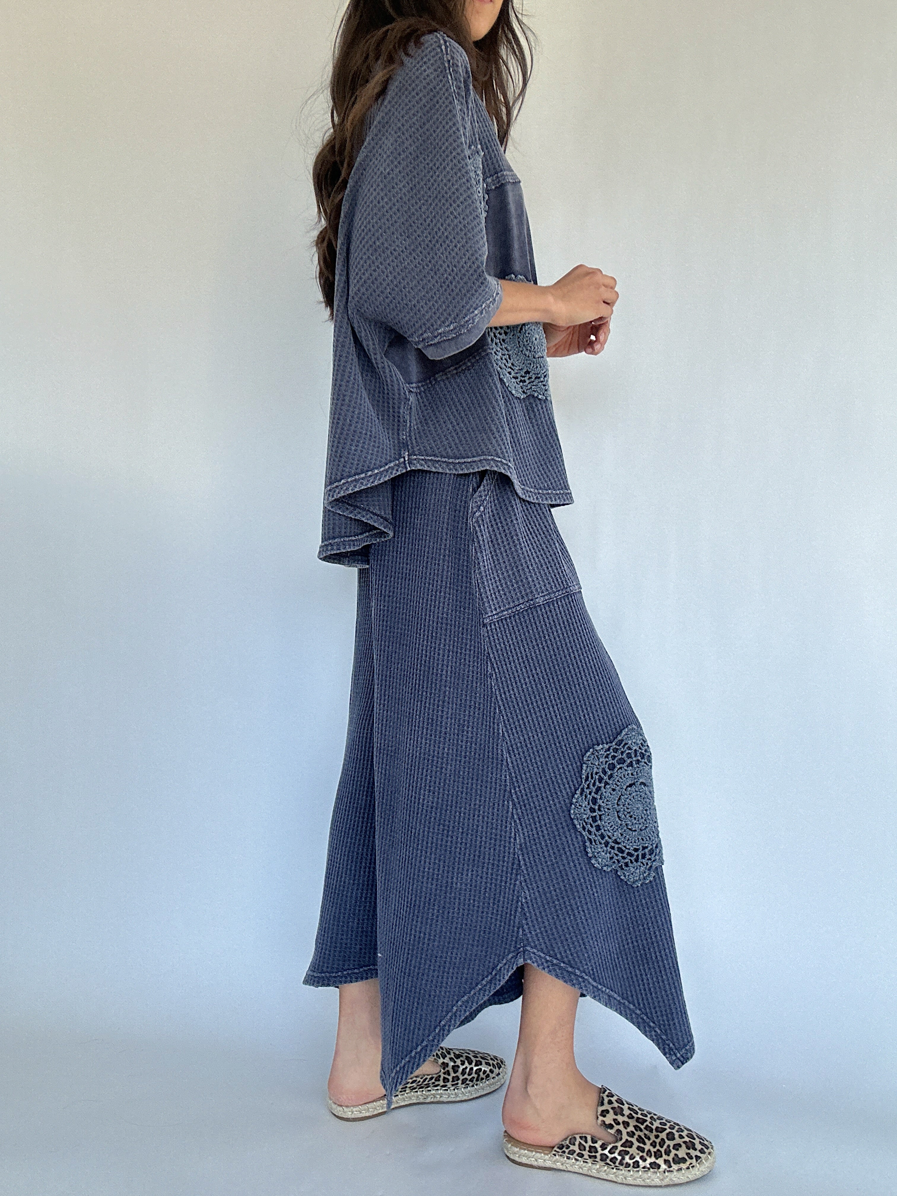 Woman wearing a blue textured outfit with a white background