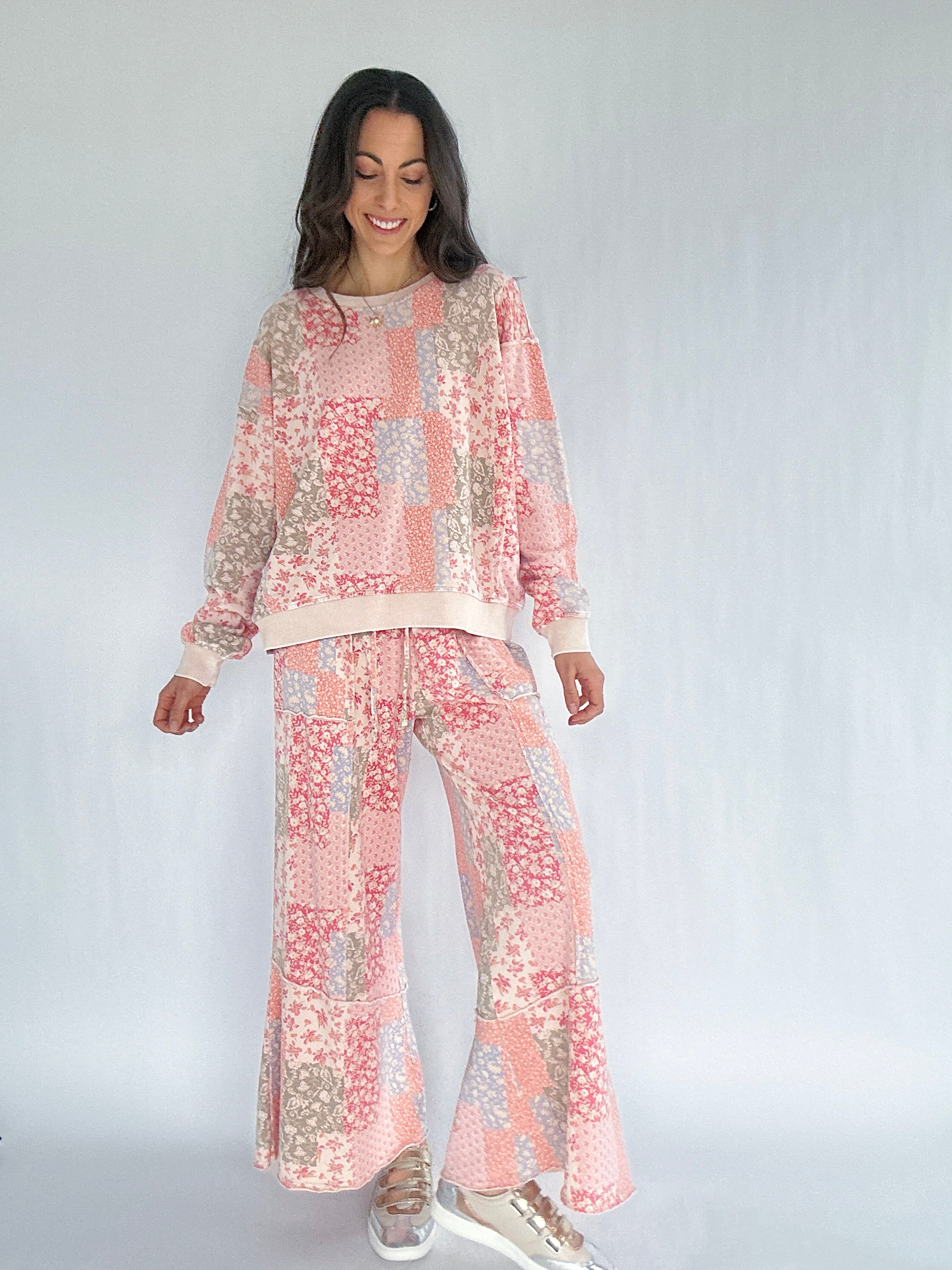 Woman wearing a floral patterned outfit on a white background