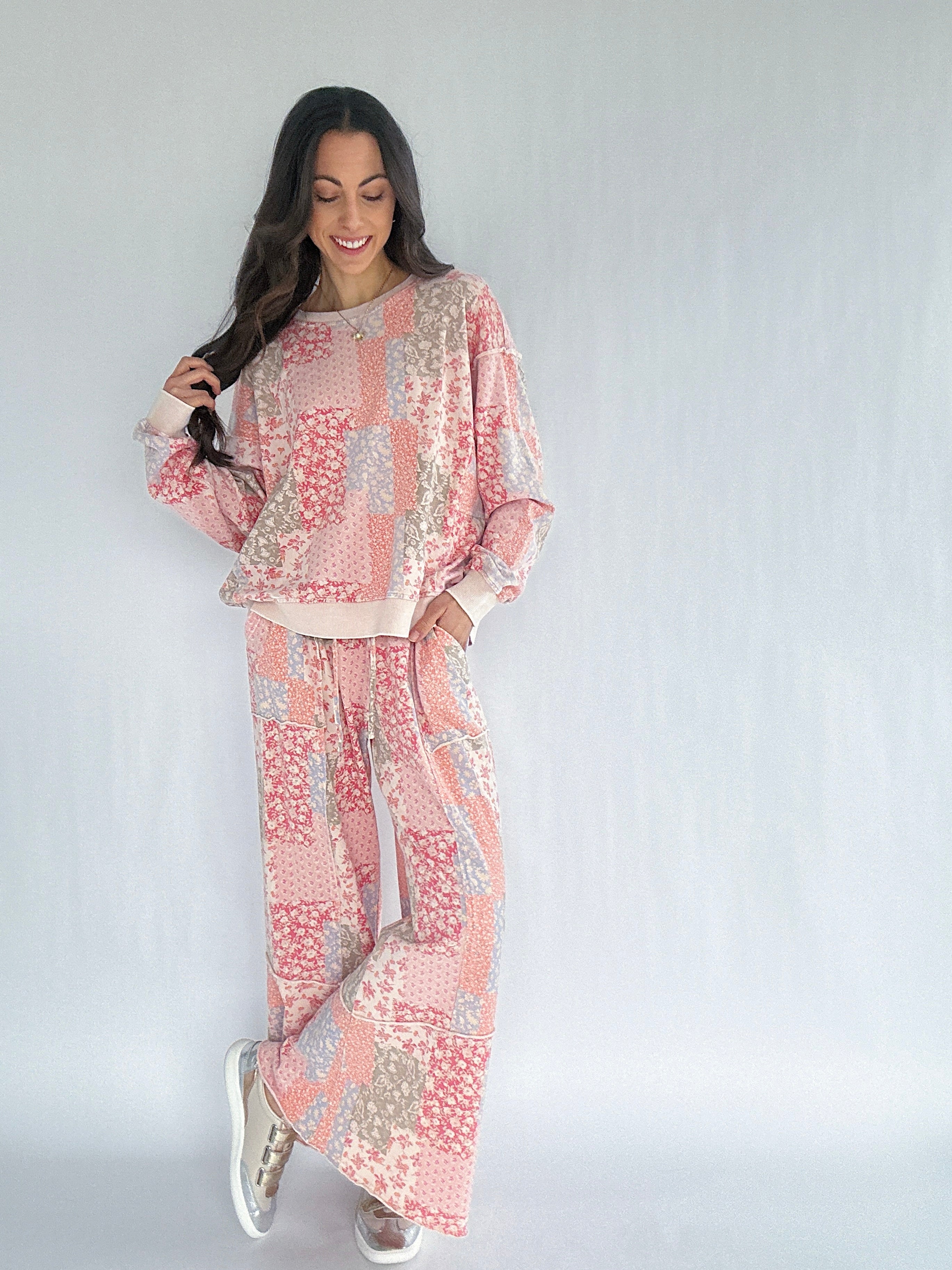 Woman wearing a pink and beige floral patchwork patterned matching outfit on a white background