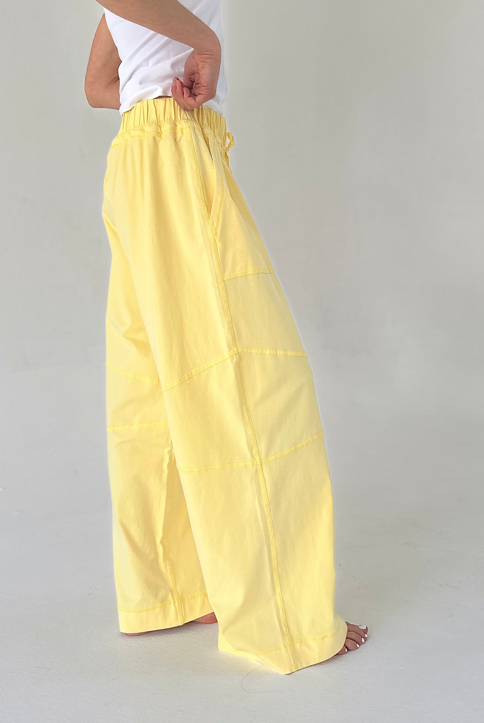 Person wearing yellow wide-leg pants on a plain background
