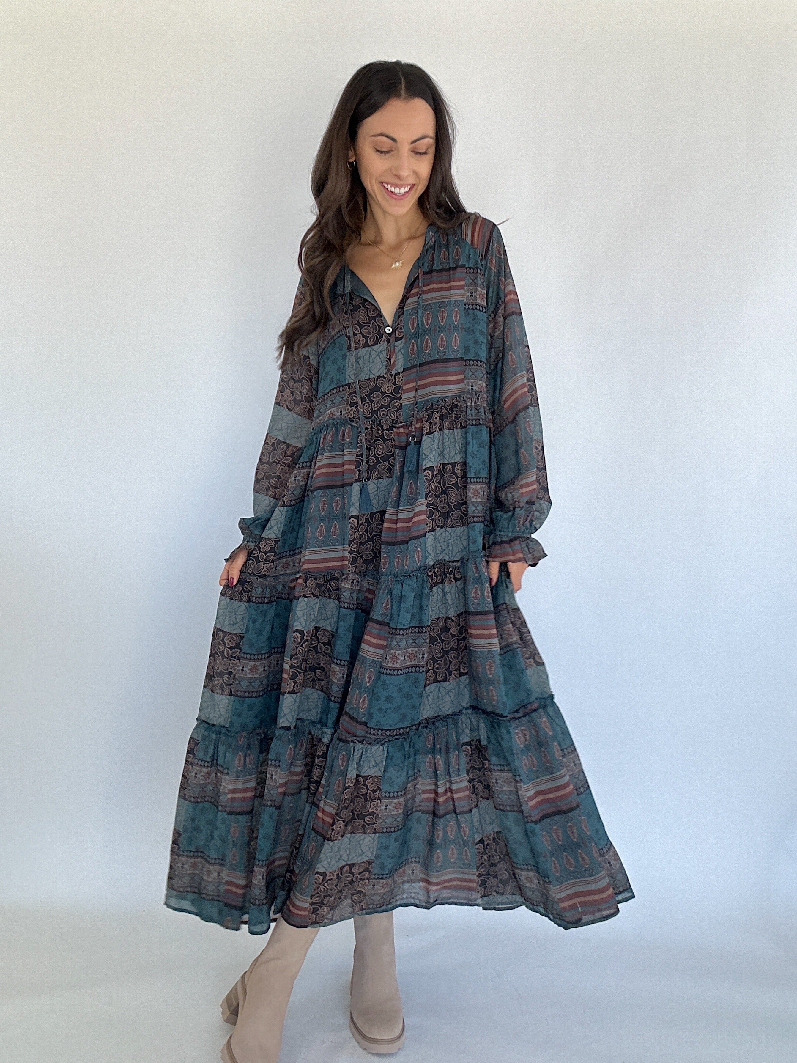 Woman wearing a long, patterned dress against a white background