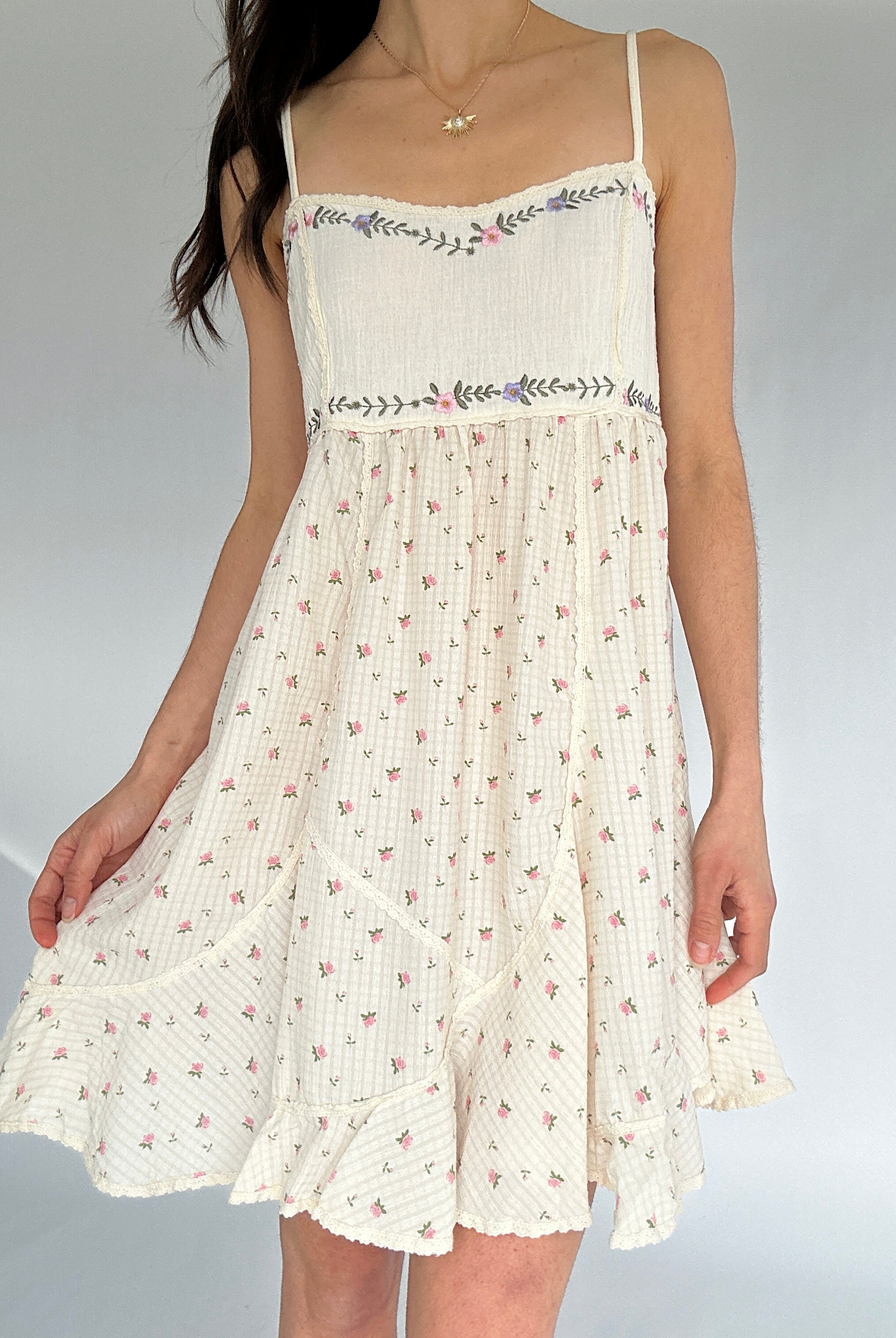 White floral dress with thin straps on a plain background