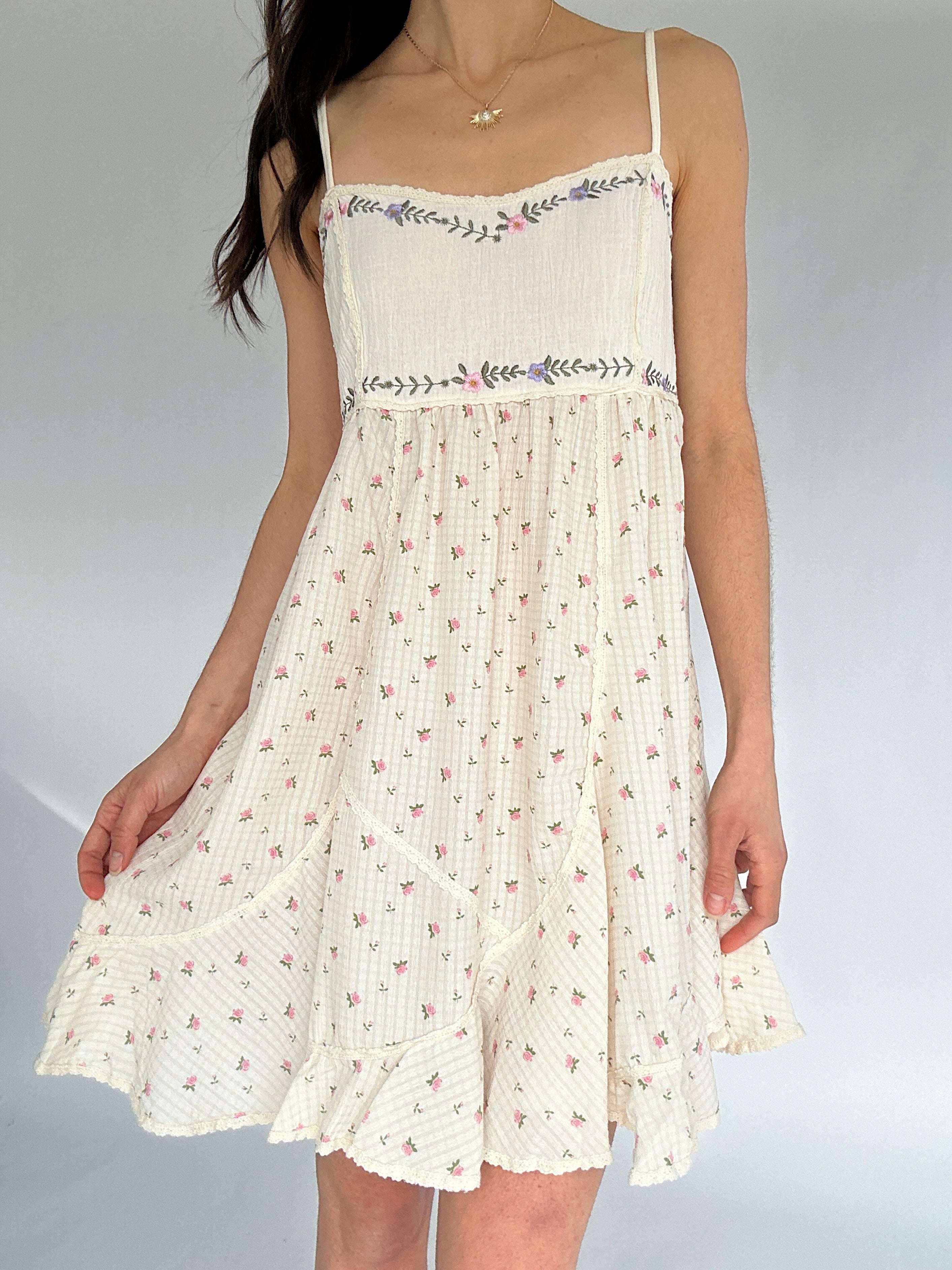 White floral dress with thin straps on a plain background