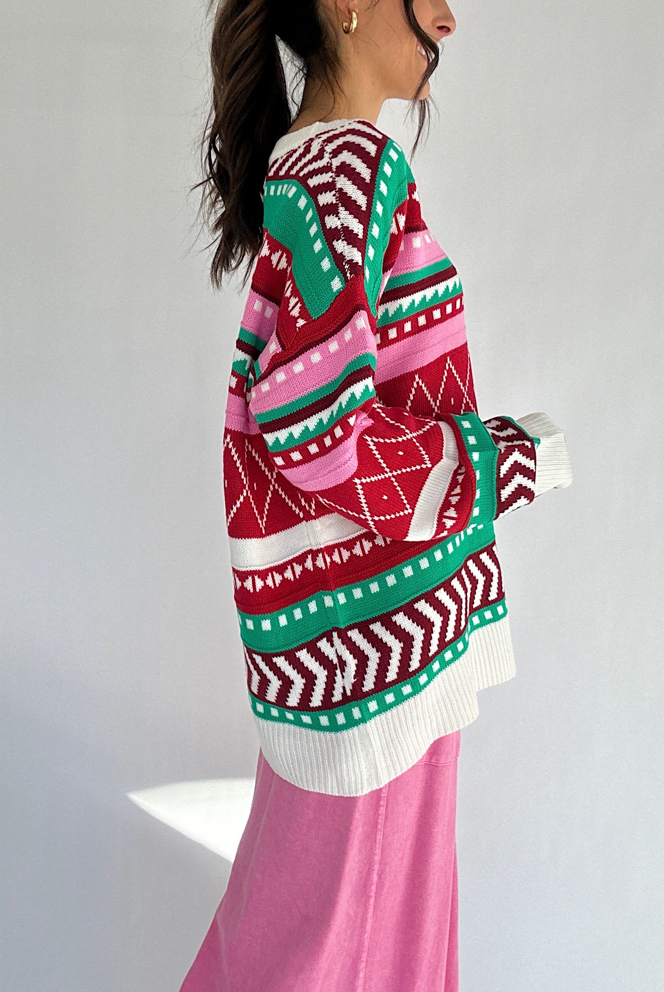 Person wearing a colorful patterned sweater with a white background