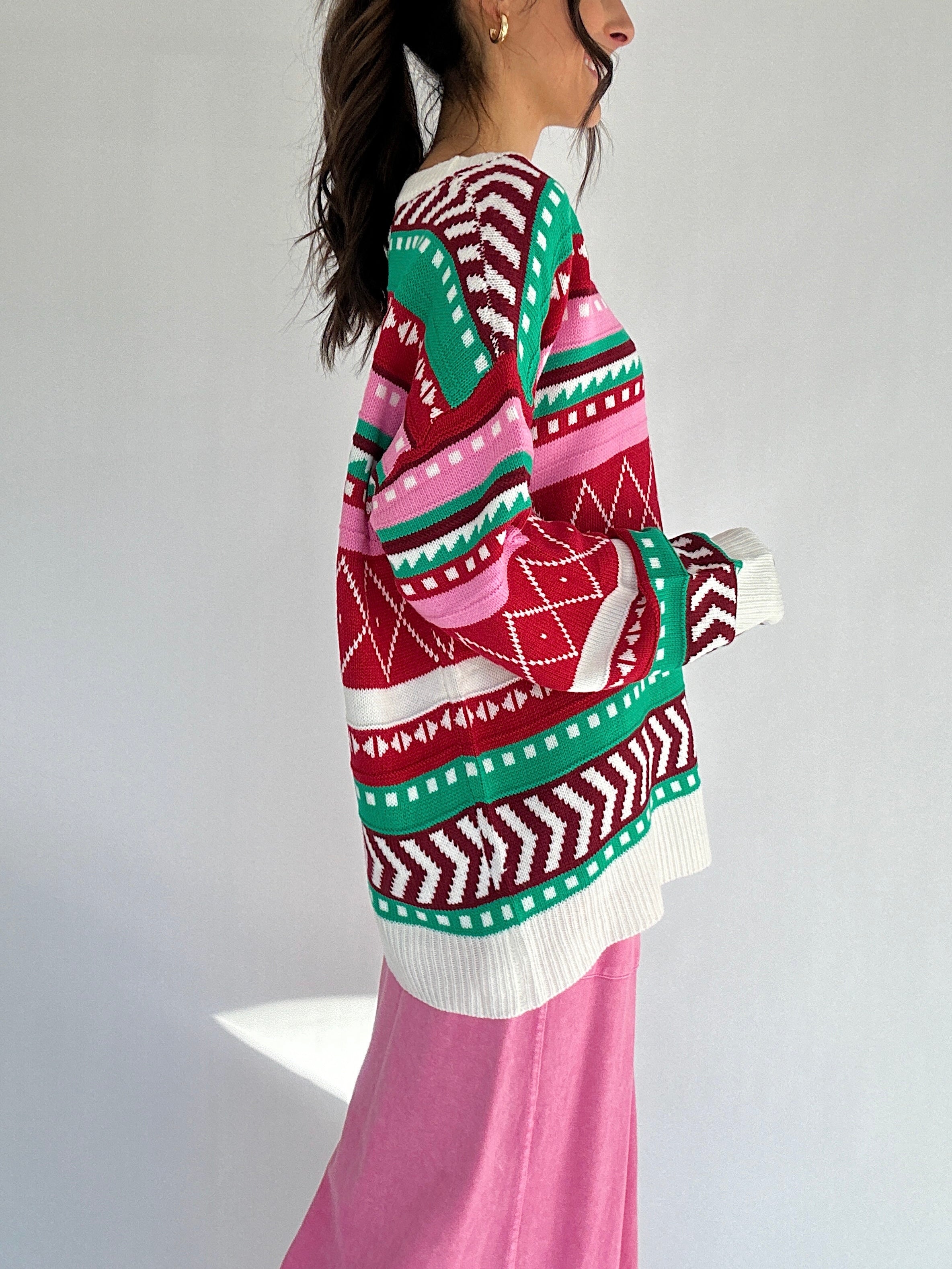 Person wearing a colorful patterned sweater with a white background