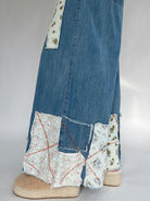 Denim pants with floral patchwork and espadrille clogs on a white gray background to show patchwork details