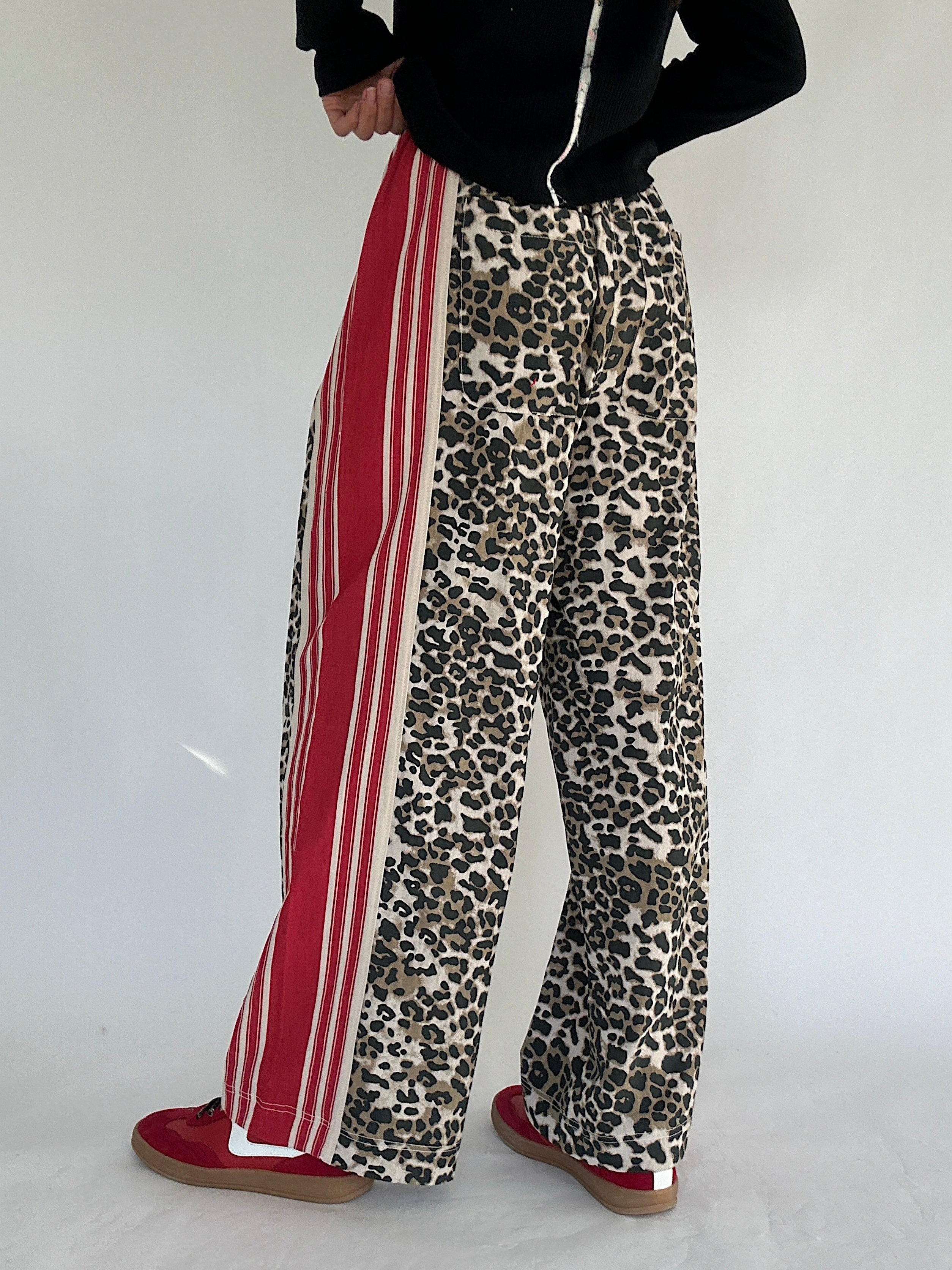 Leopard print pants with red stripes on a white background