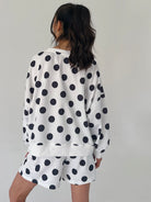 Person wearing a polka dot outfit with a white background