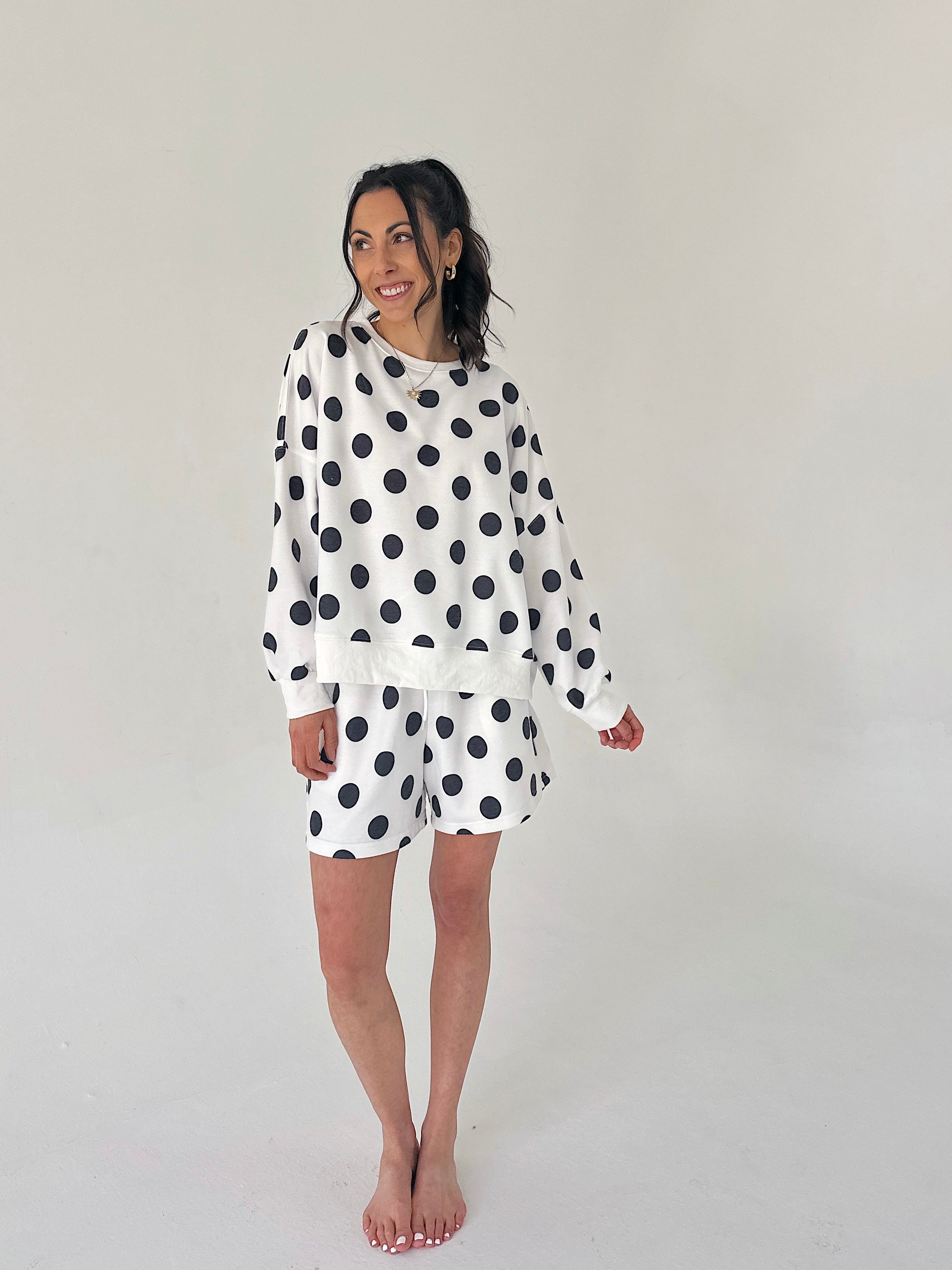 Woman wearing a polka dot set on a plain background