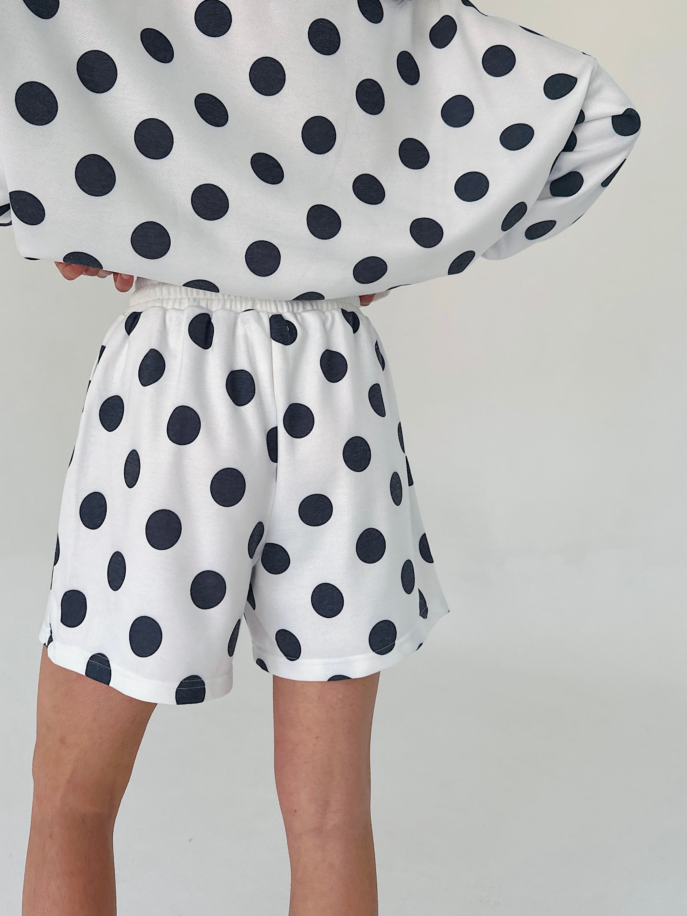 Person wearing a polka dot outfit with a white background