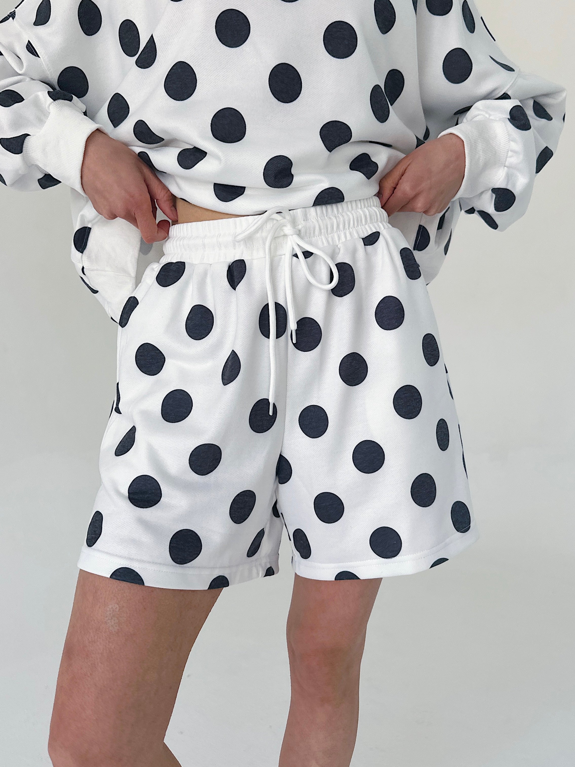 Person wearing a polka dot outfit with a white background